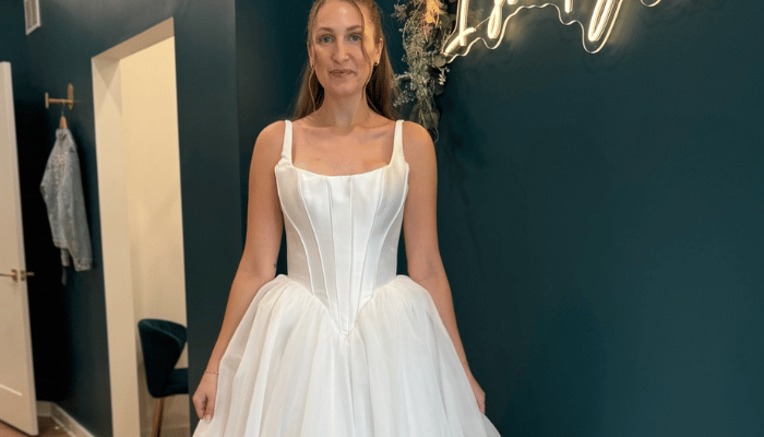 Bride wearing a satin corset wedding dress with a full tulle skirt during a bridal appointment at Two Hearts Bridal