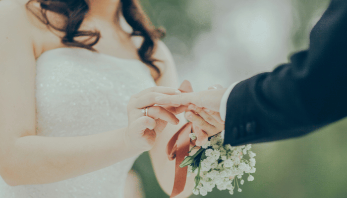 Bride and groom exchanging rings during an outdoor wedding ceremony