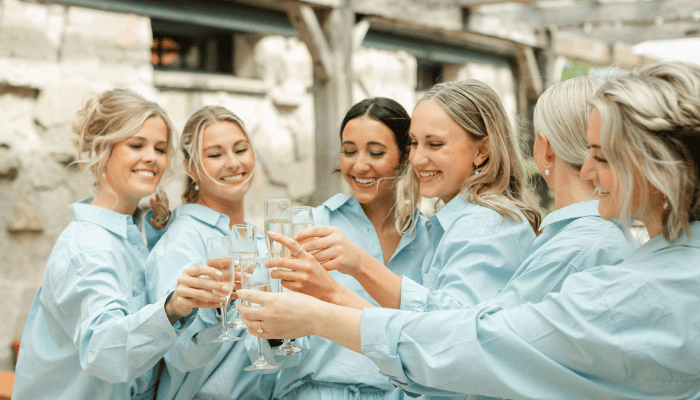 Bridesmaids celebrating together before the wedding with a champagne toast