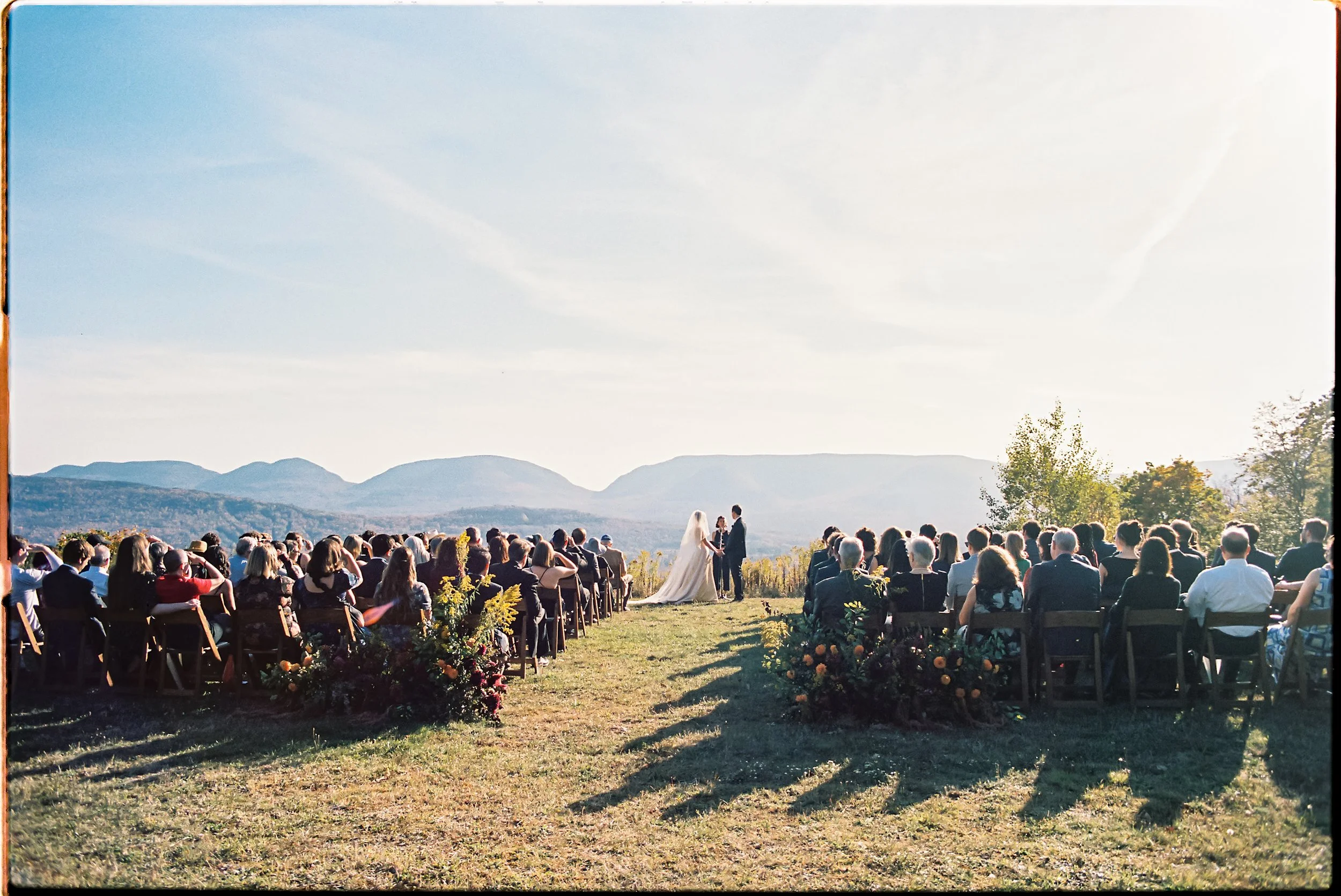Outdoor ceremony at Deer Mountain Inn framed by seasonal floral arrangements and mountain landscape