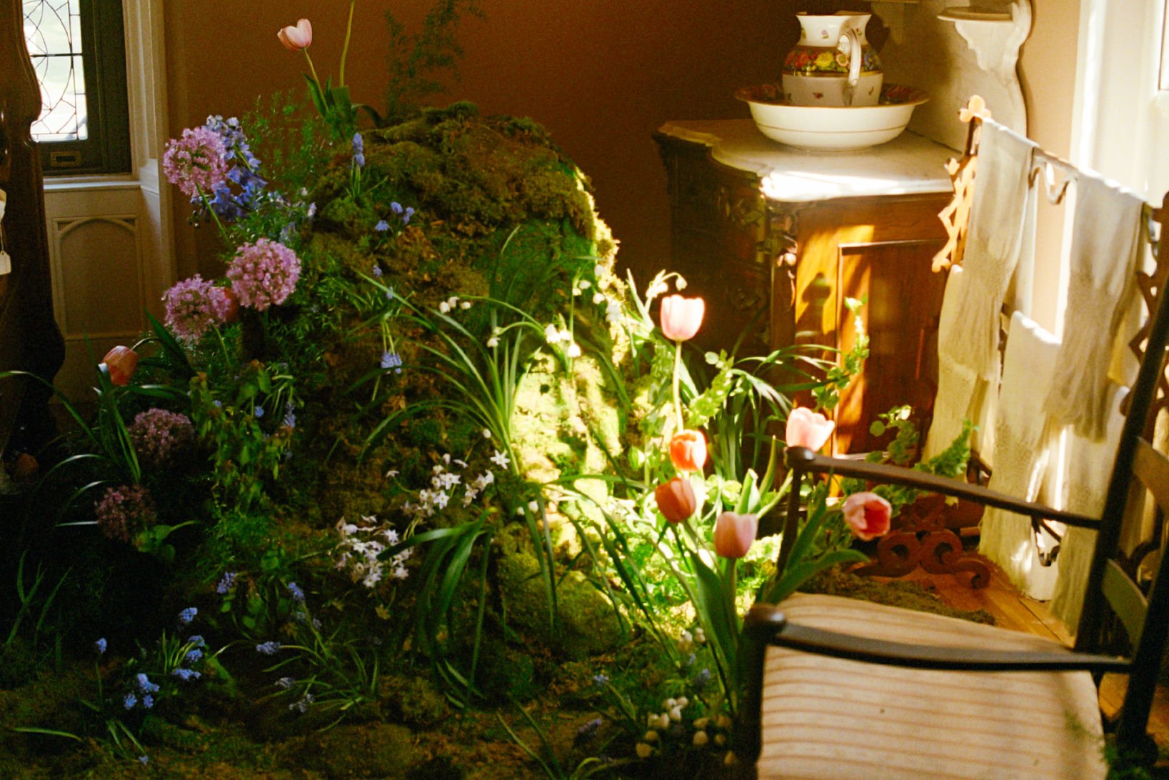  sun-soaked  moss mound covered in blooming tulips, and various soft pastel flowers. 