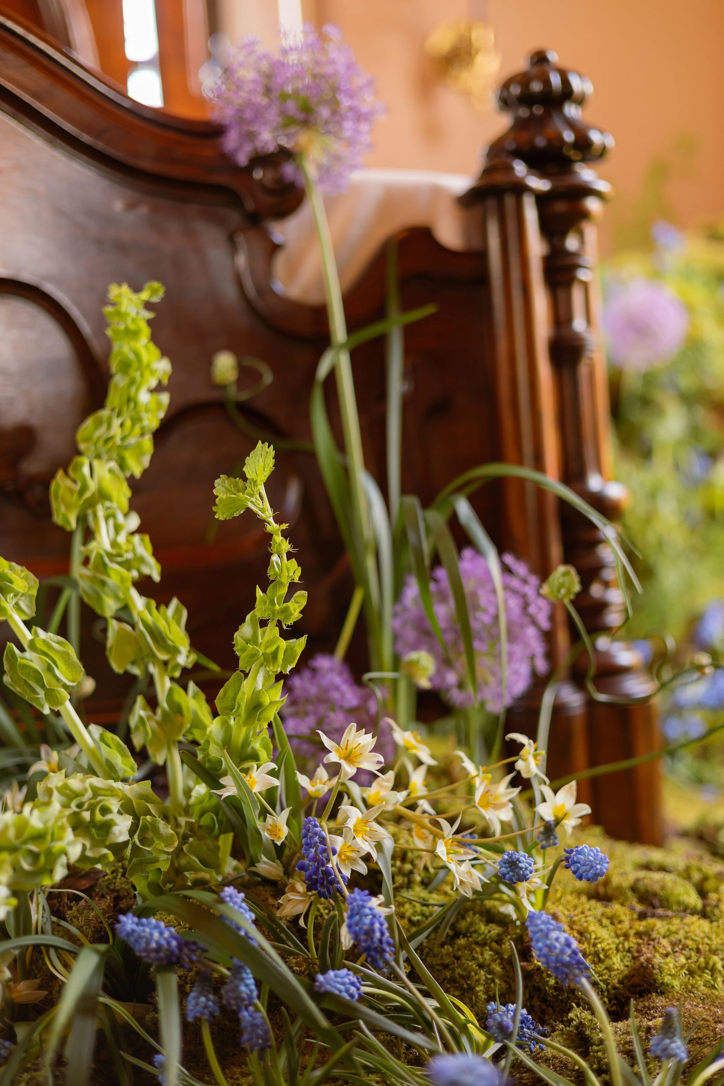  Fresh Allium, bells of Ireland, lilies, and petite hyacinth covering heritage floors 