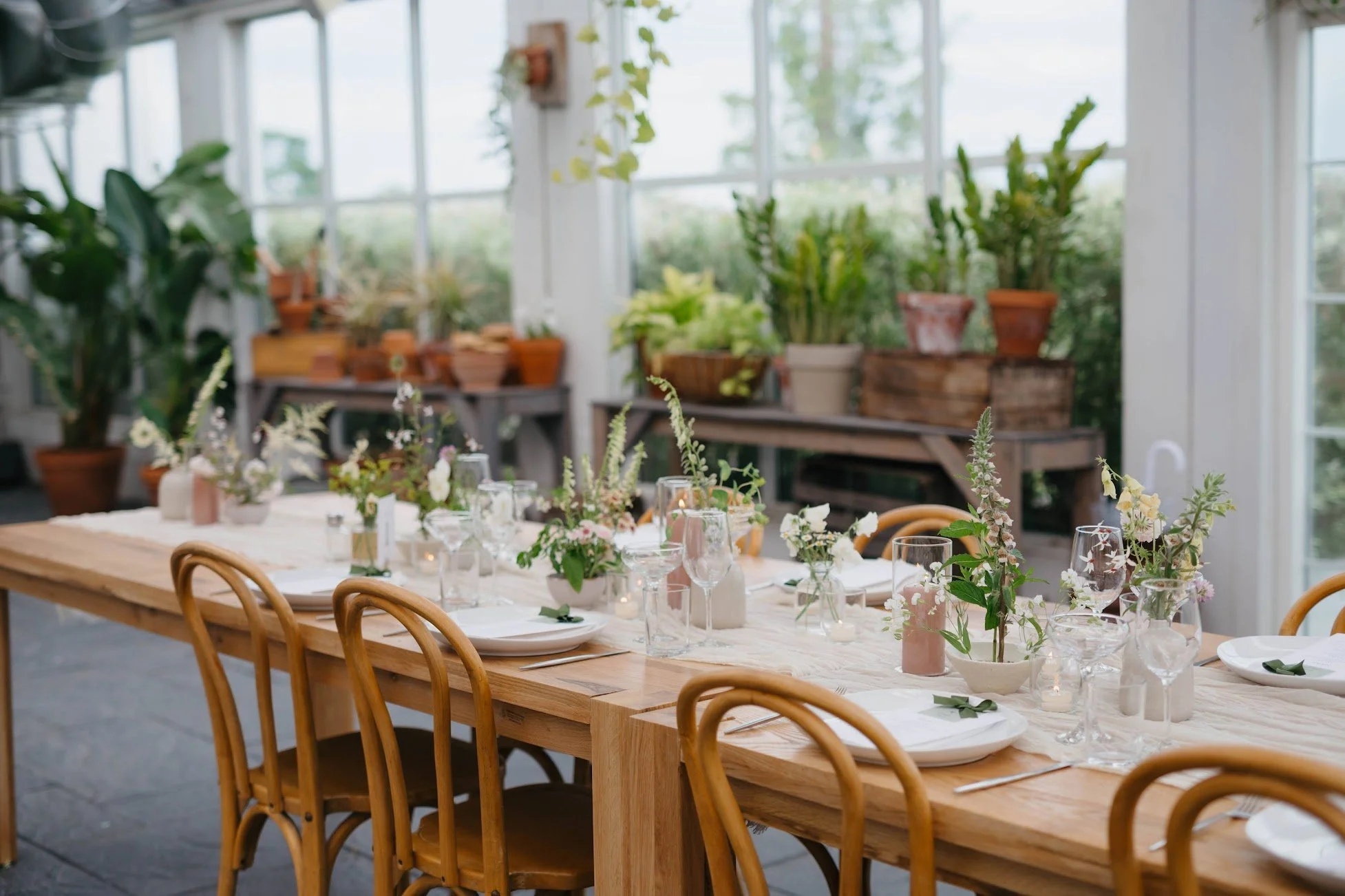  Long reception table curated with tall candles in glass and romantic wedding florals    