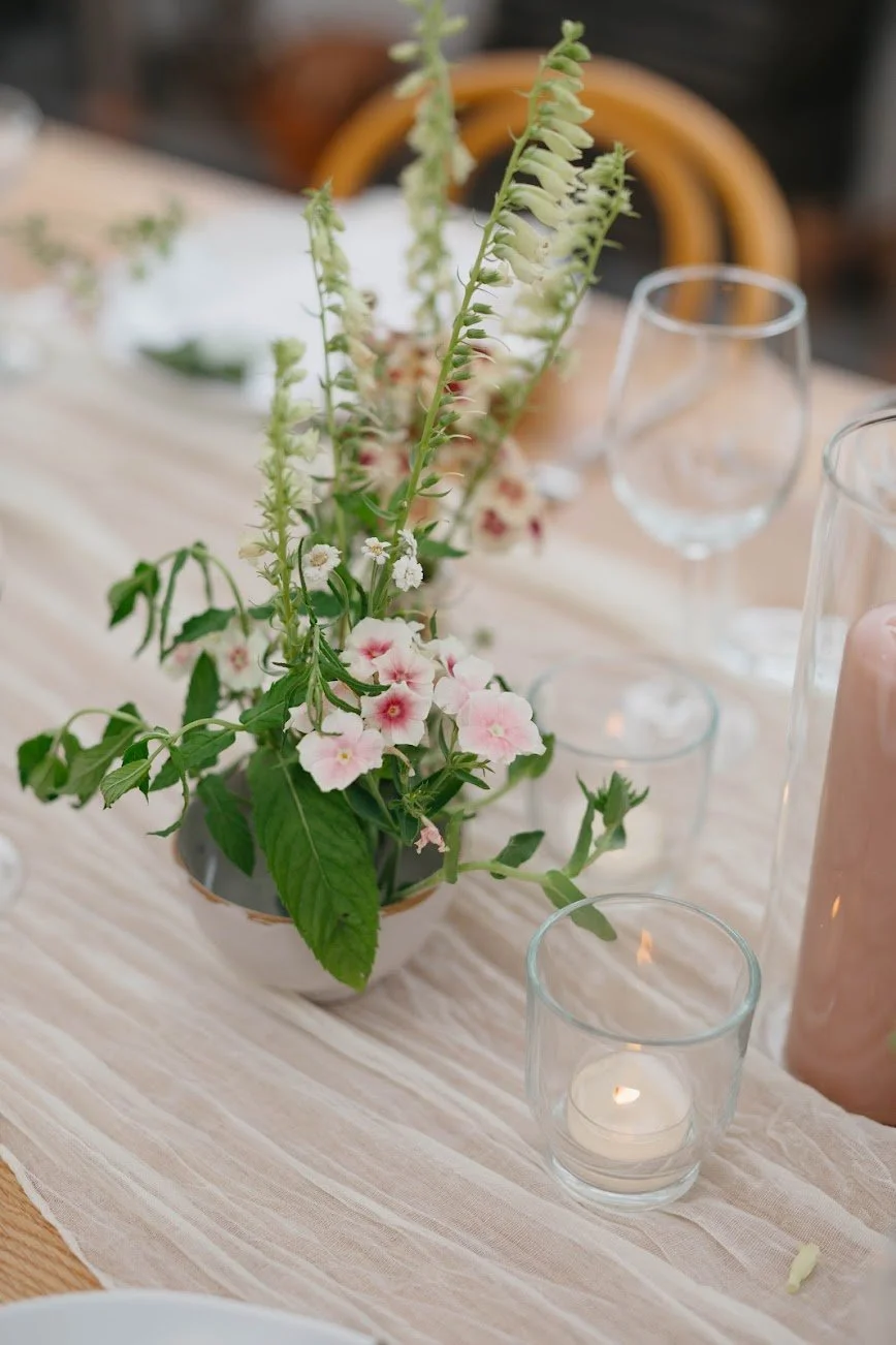  Small, intimate assortment with tiny pink flowers next to votive  