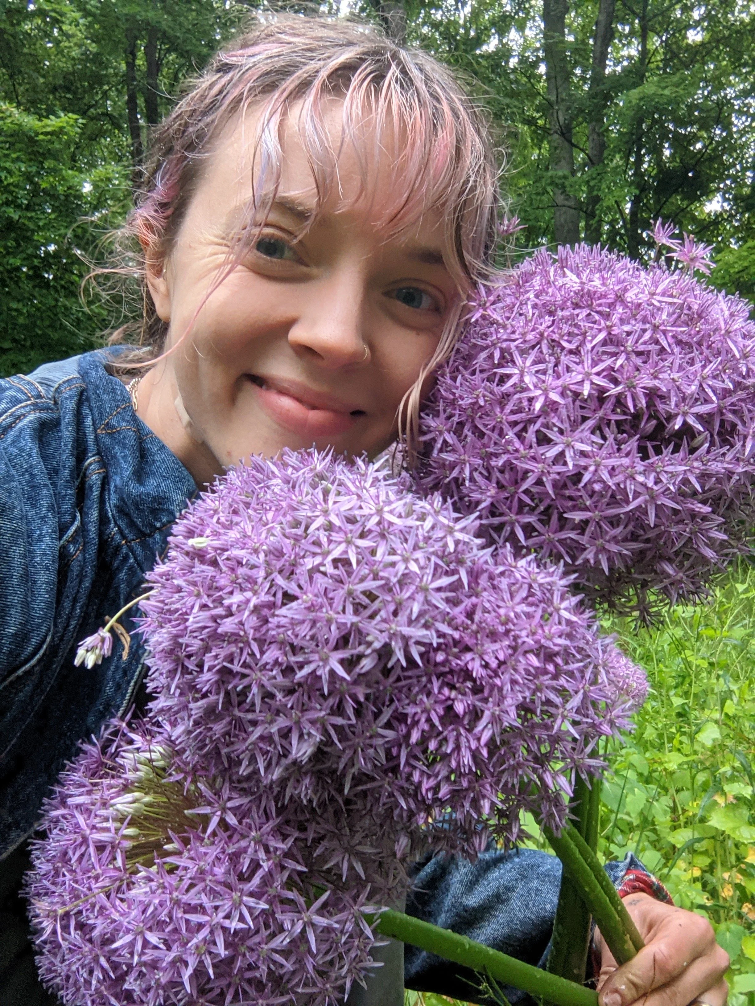 Florist smiling next to huge delicate purple flowers of these spring giants 