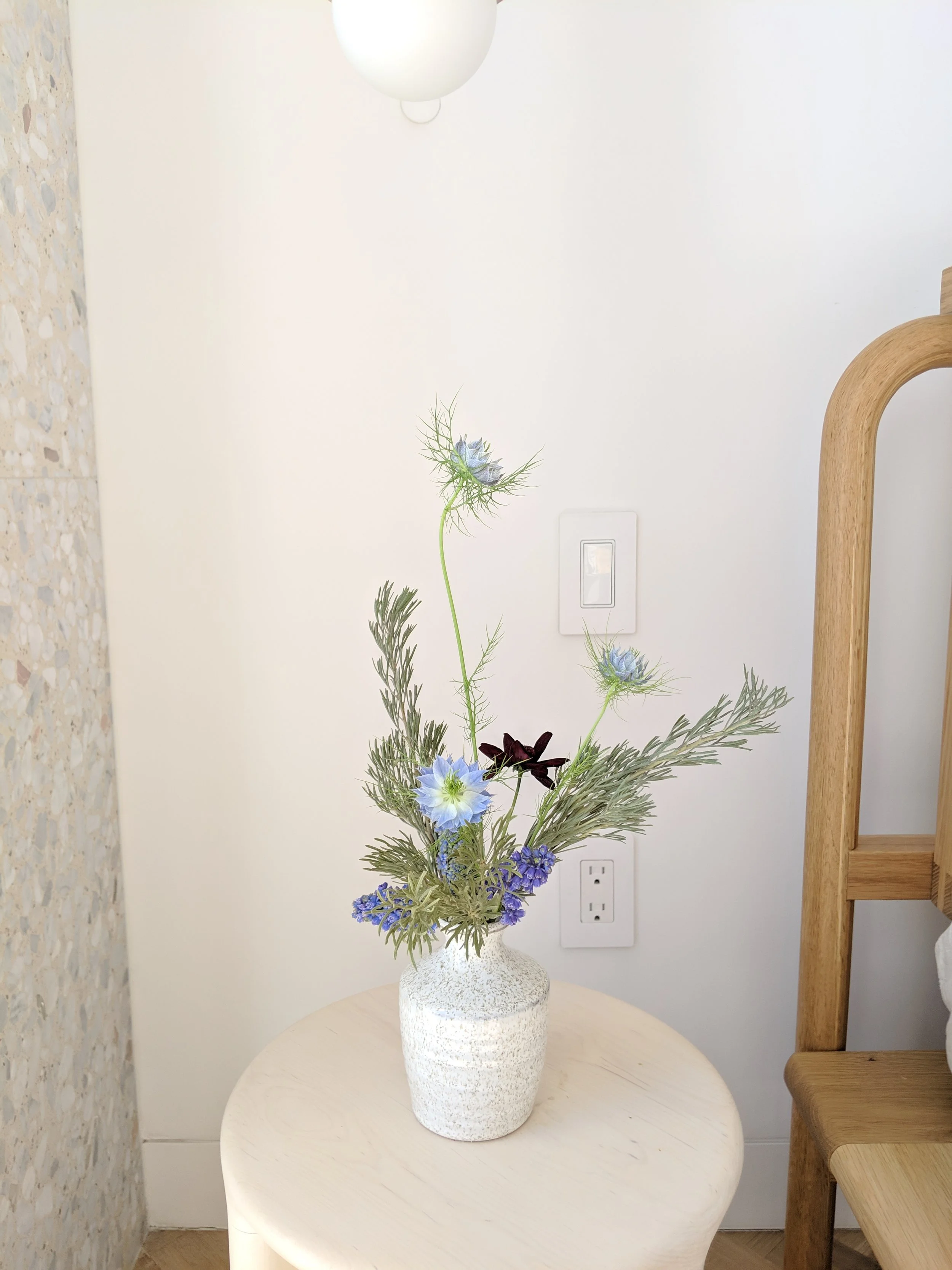  Sculptural bouquet of nigella creates a bold centerpiece in simple white ceramic vase   