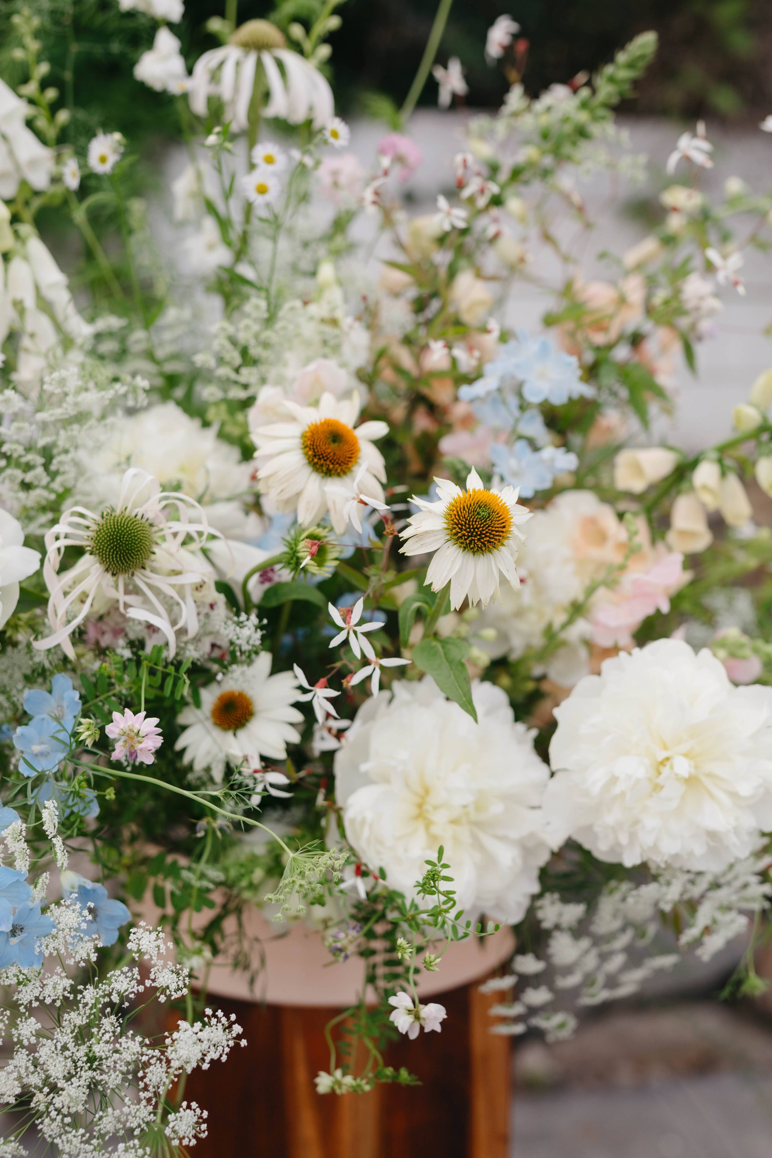  Arrangement of white toned florals featuring queens annes lace and coneflowers. 