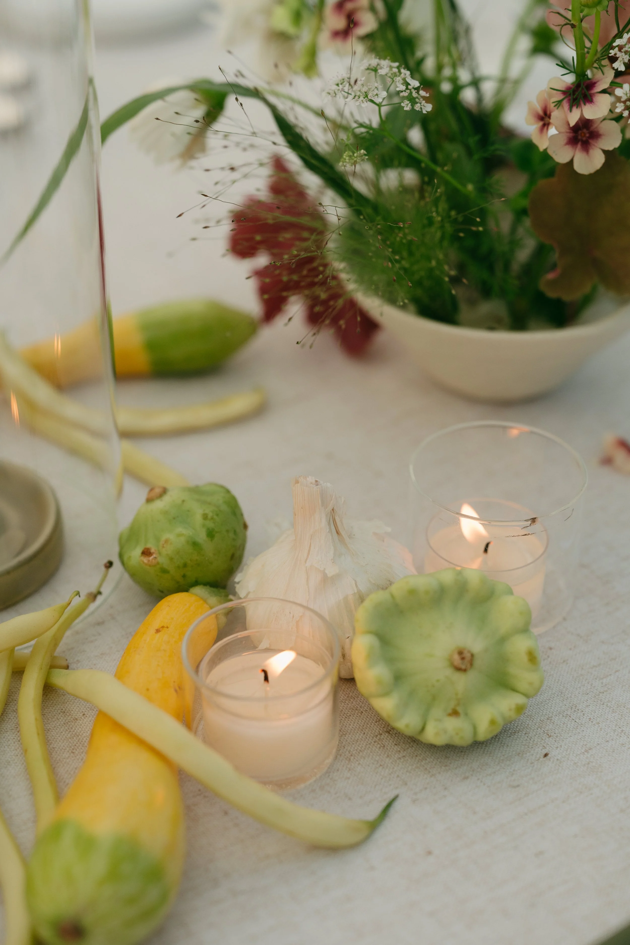 Loose table florals paired with seasonal squash and candlelight on linen table