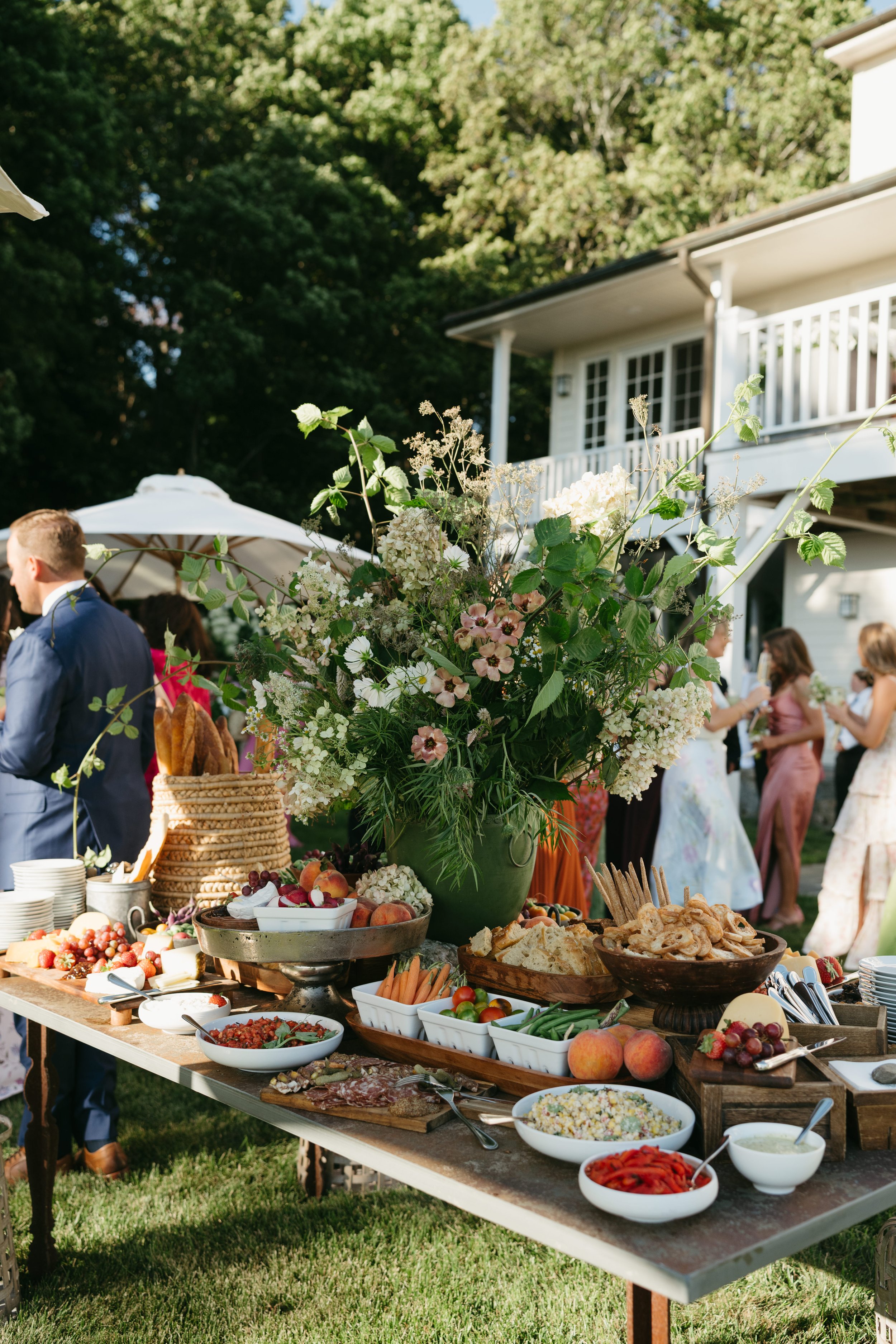 Loose garden florals arranged along outdoor reception table at private residence