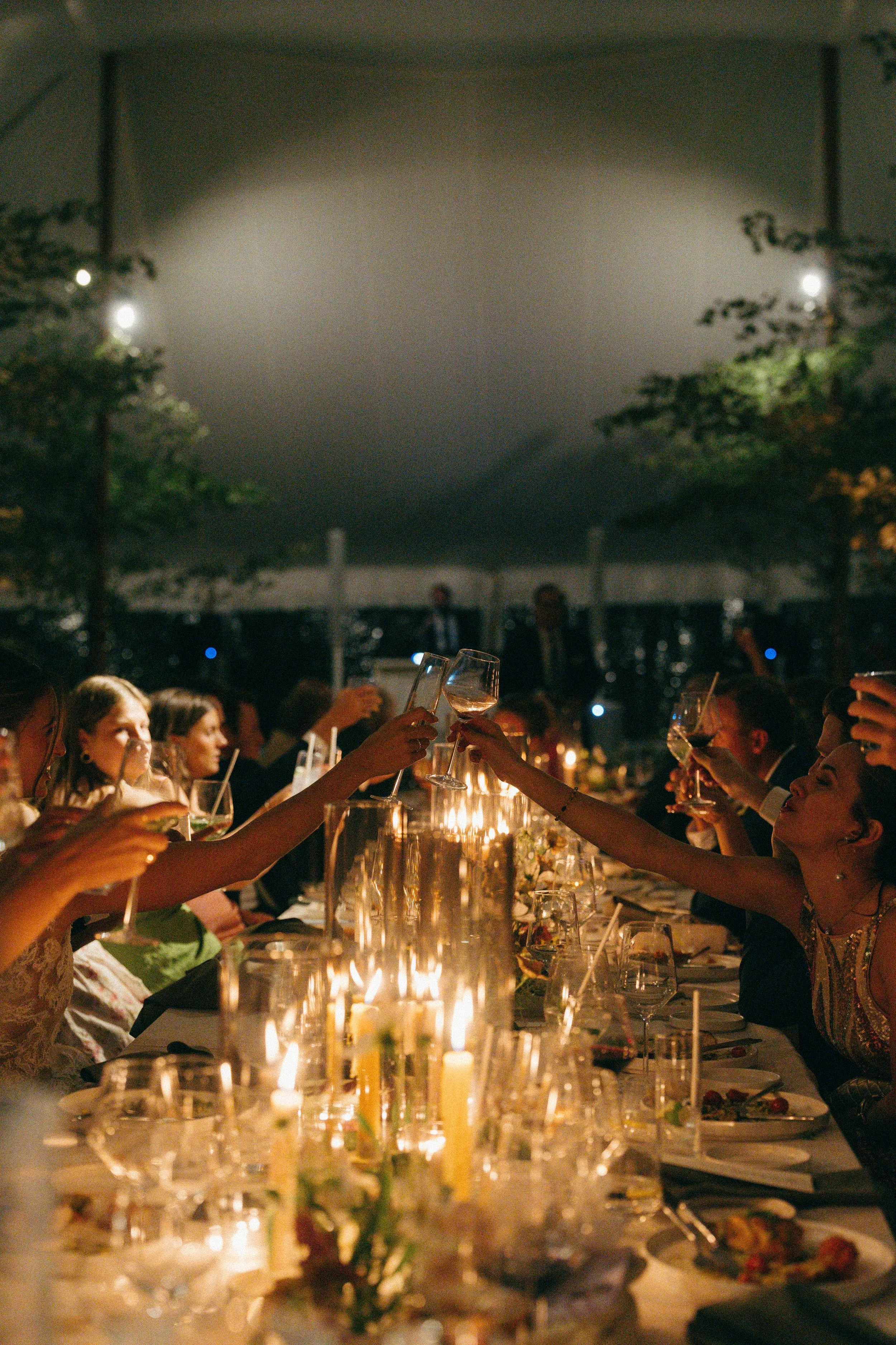 Long dinner tables lined with glowing candles and low floral arrangements