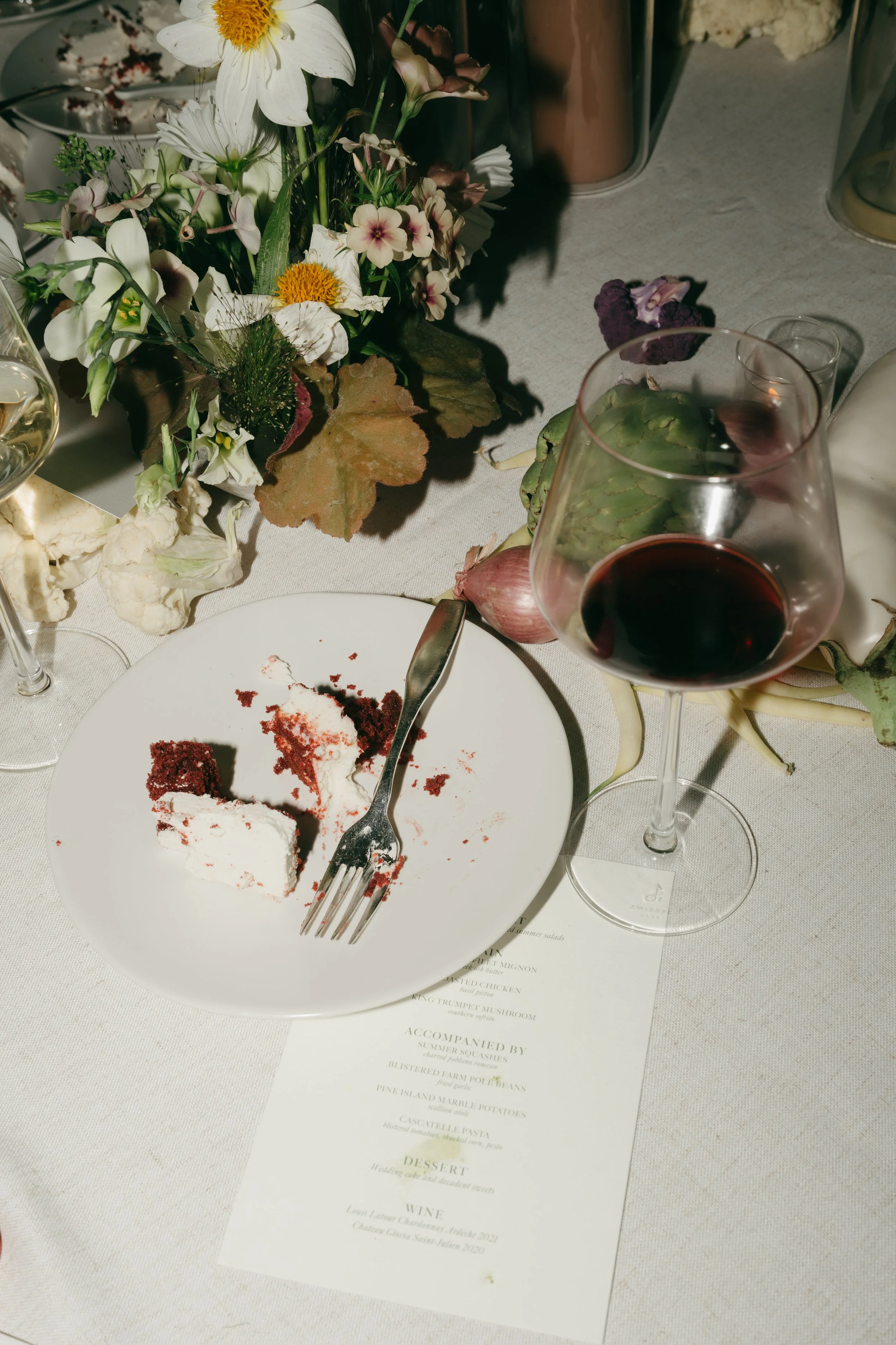 Dinner table with floral centerpiece beside dessert plate and wine glass