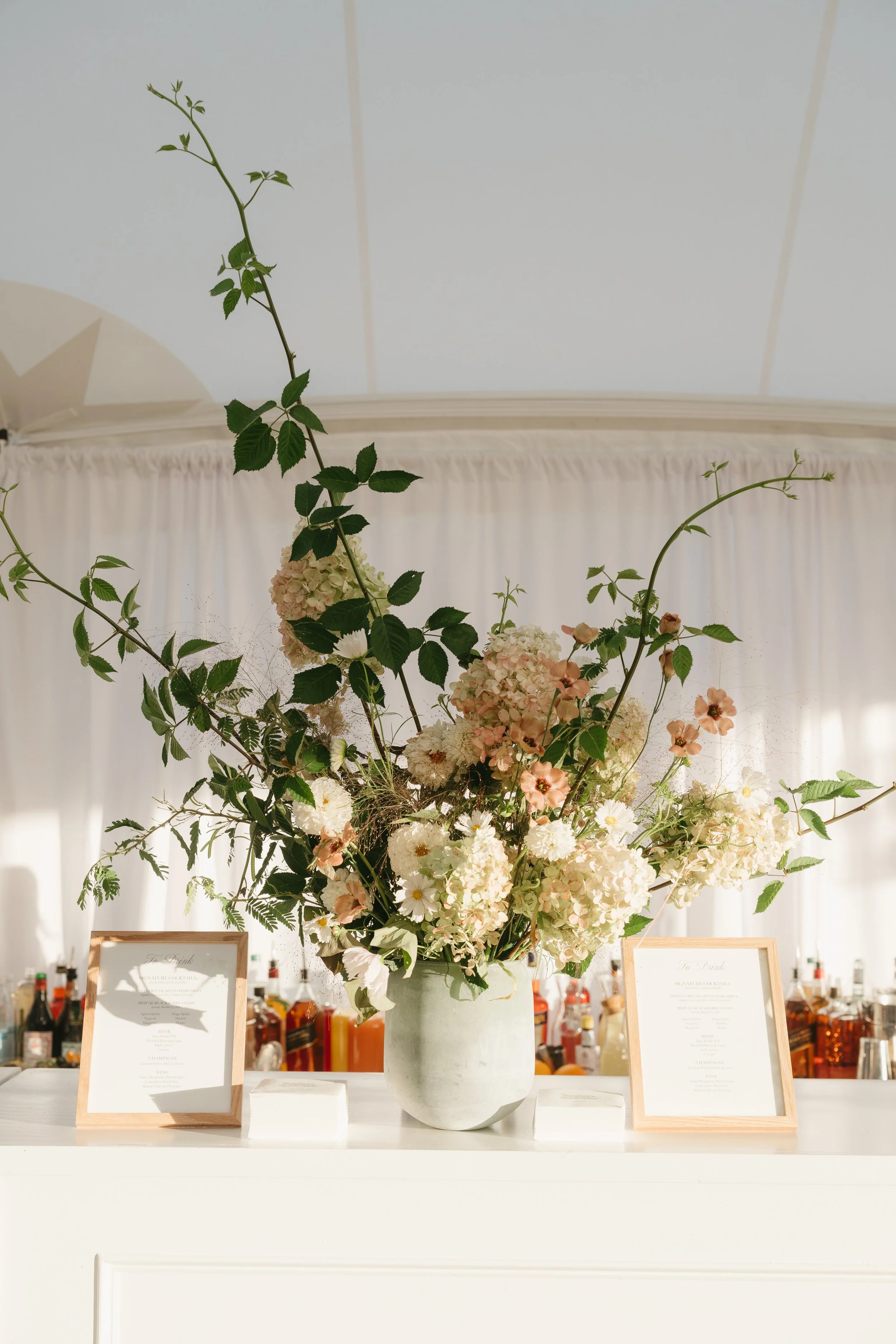 Lush floral arrangement with seasonal blooms displayed on reception bar