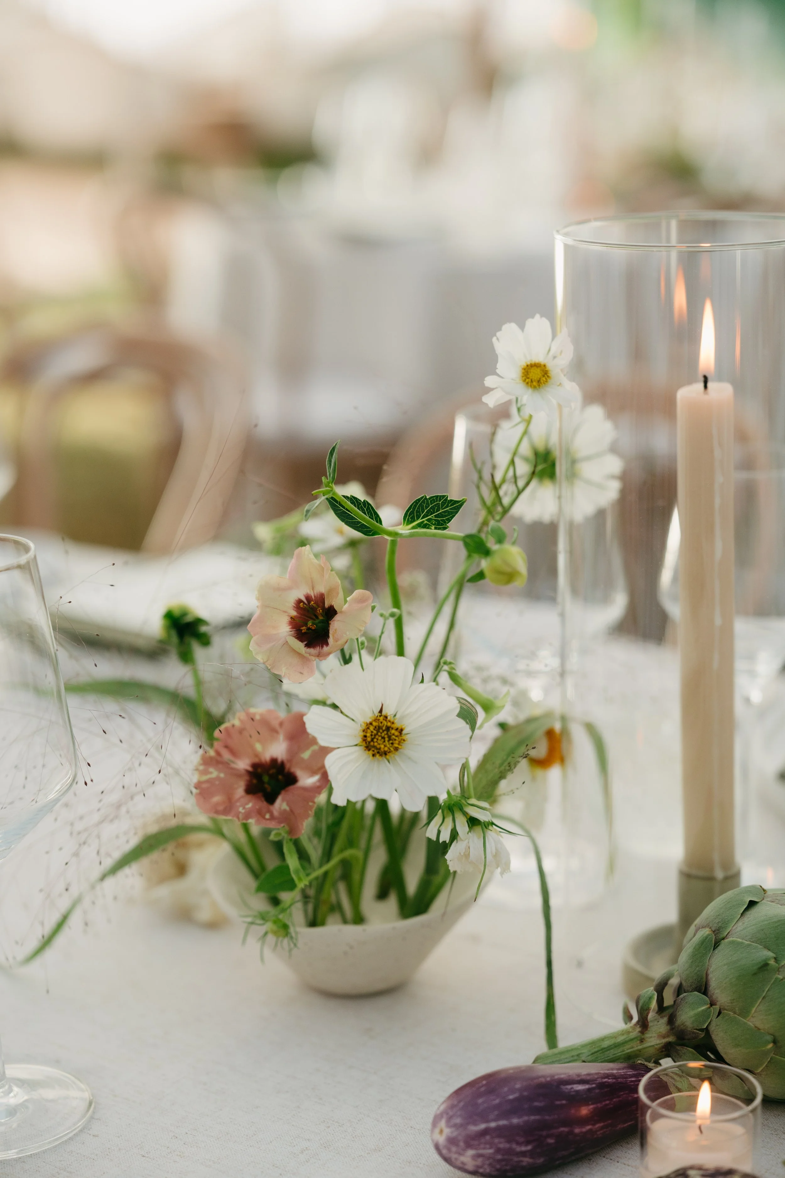 Petite floral arrangement with cosmos and greenery styled beside taper candles