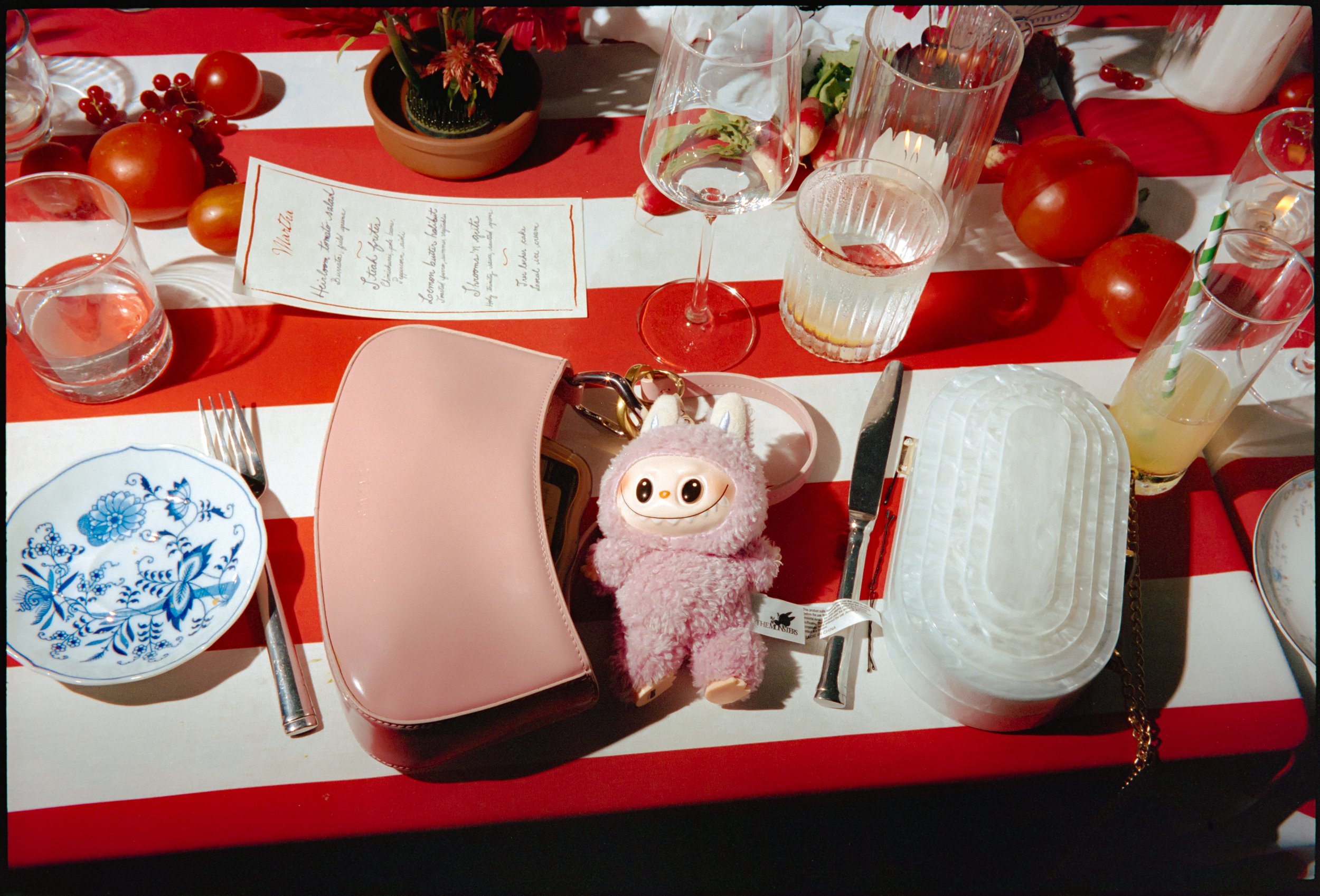 Playful table detail with striped linens, tomatoes, and place setting at estate wedding