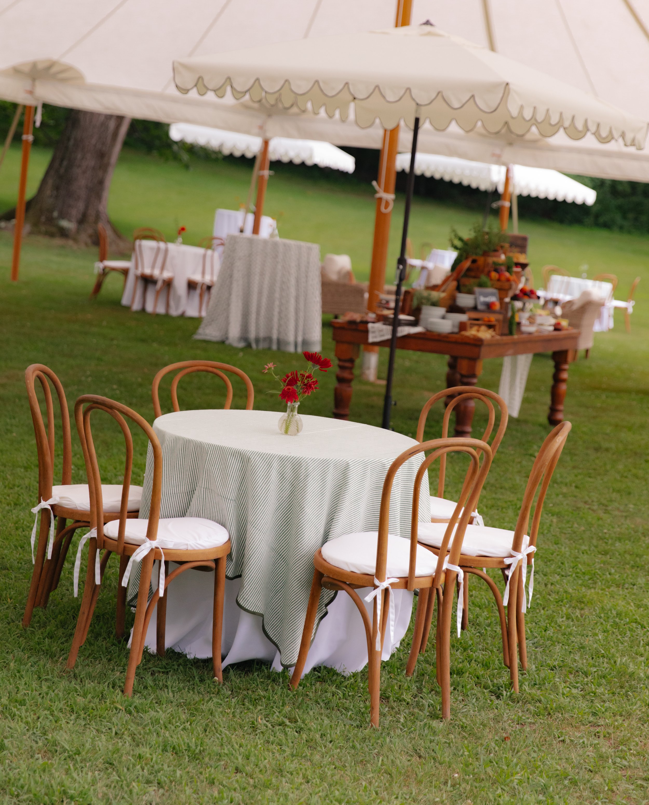 Cocktail hour setup beneath white tent on estate lawn
