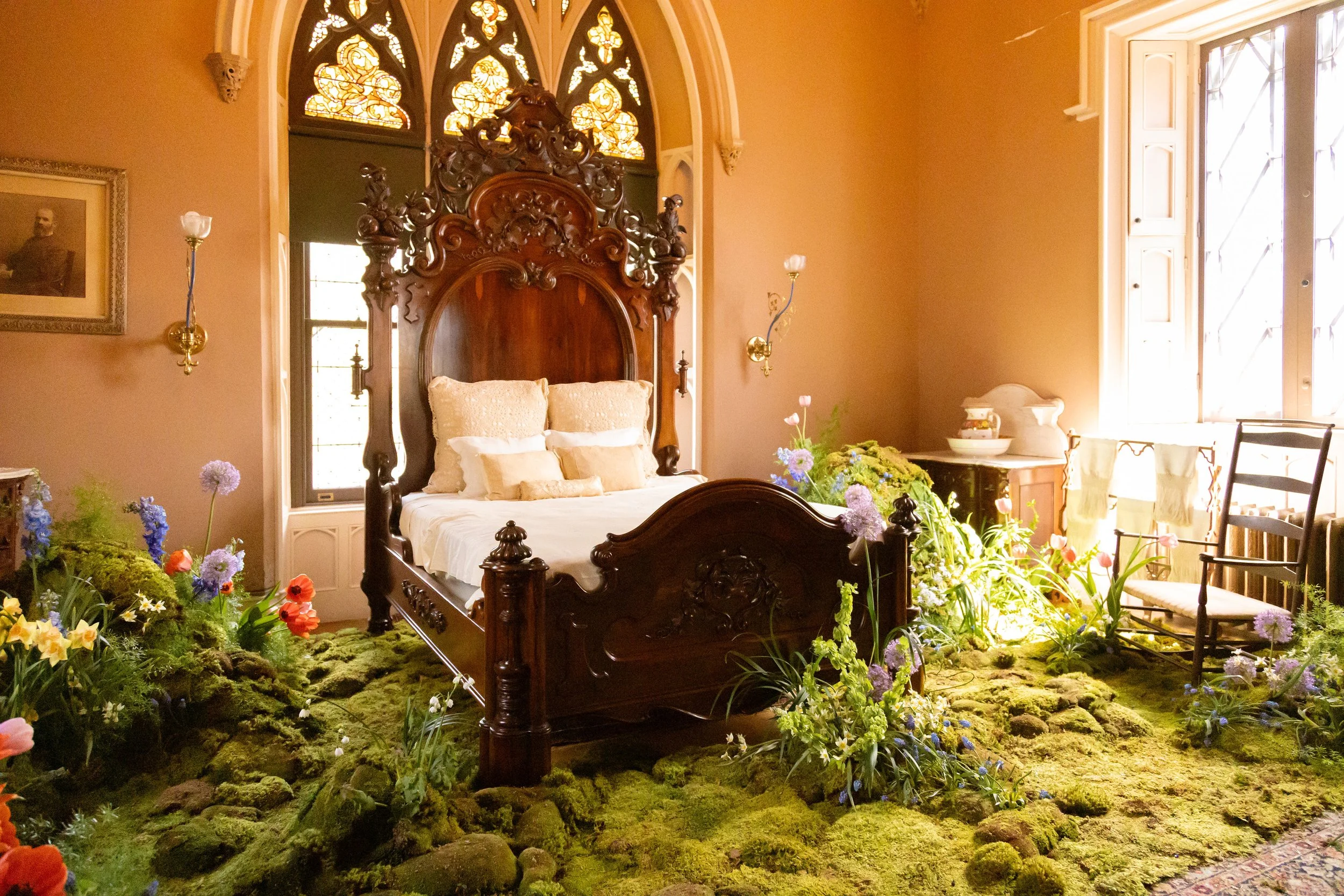 Whimsical sunlit bedroom featuring moss covered floors and timeless blossoms