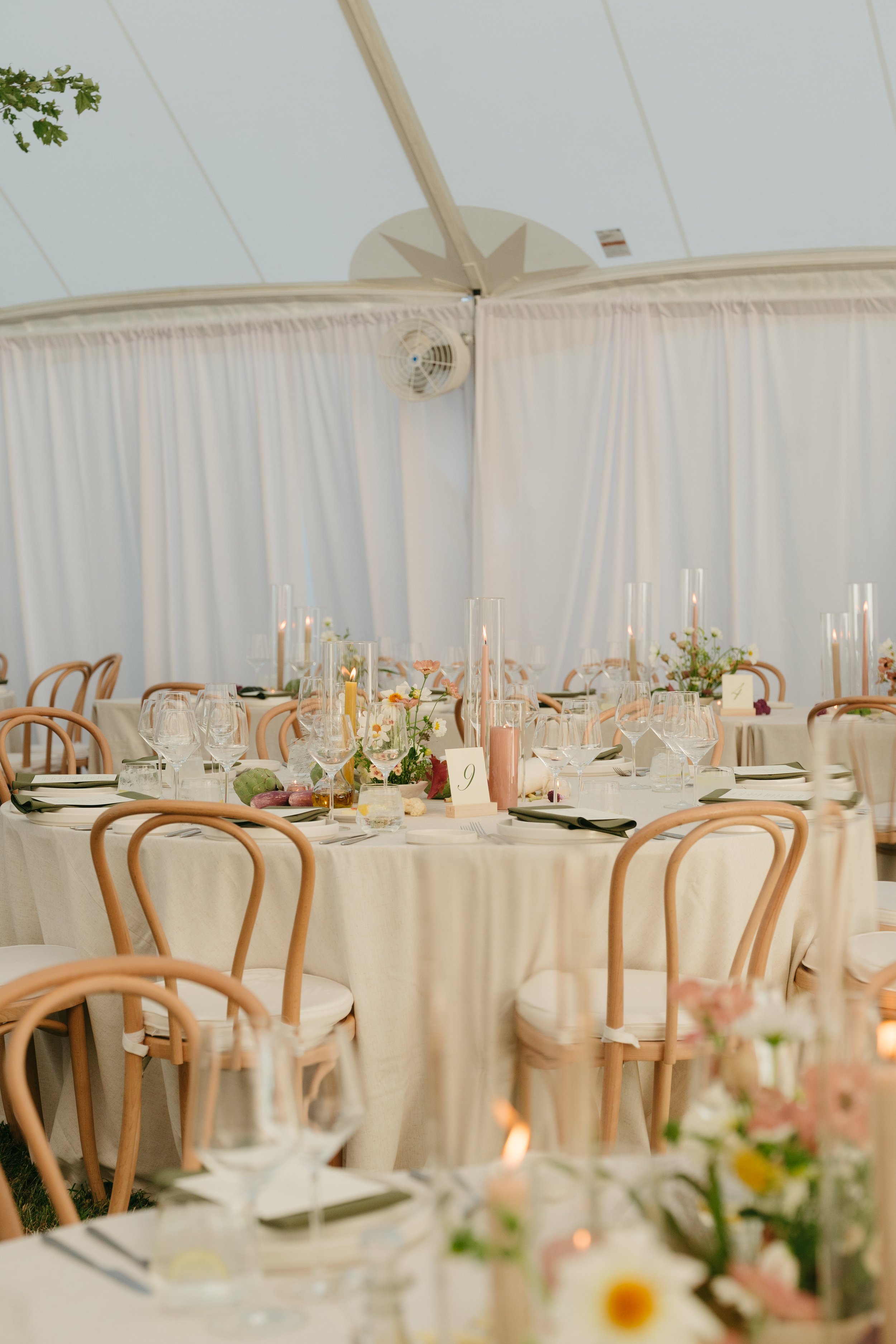 Loose floral centerpieces and taper candles styled across reception tables