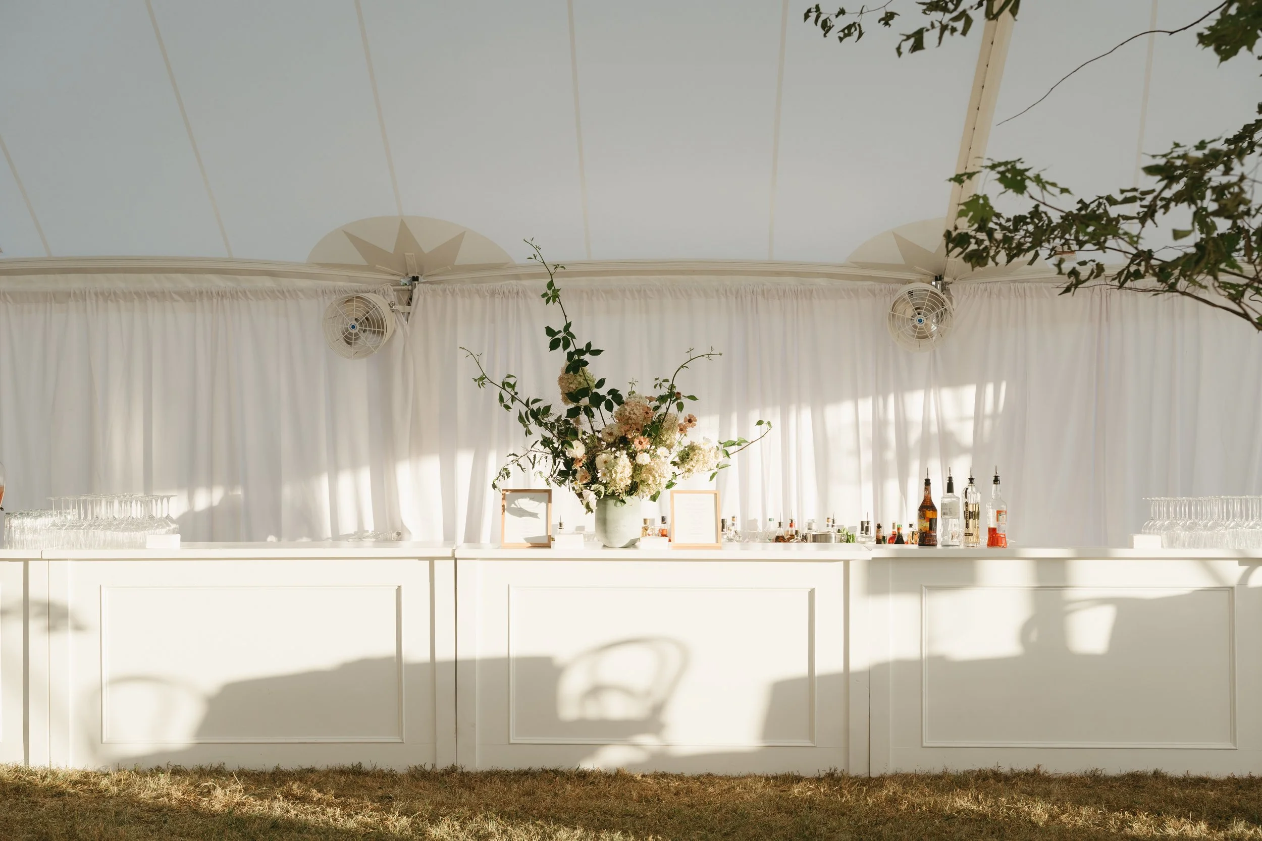 Statement floral arrangement with airy greenery and soft blooms atop white bar