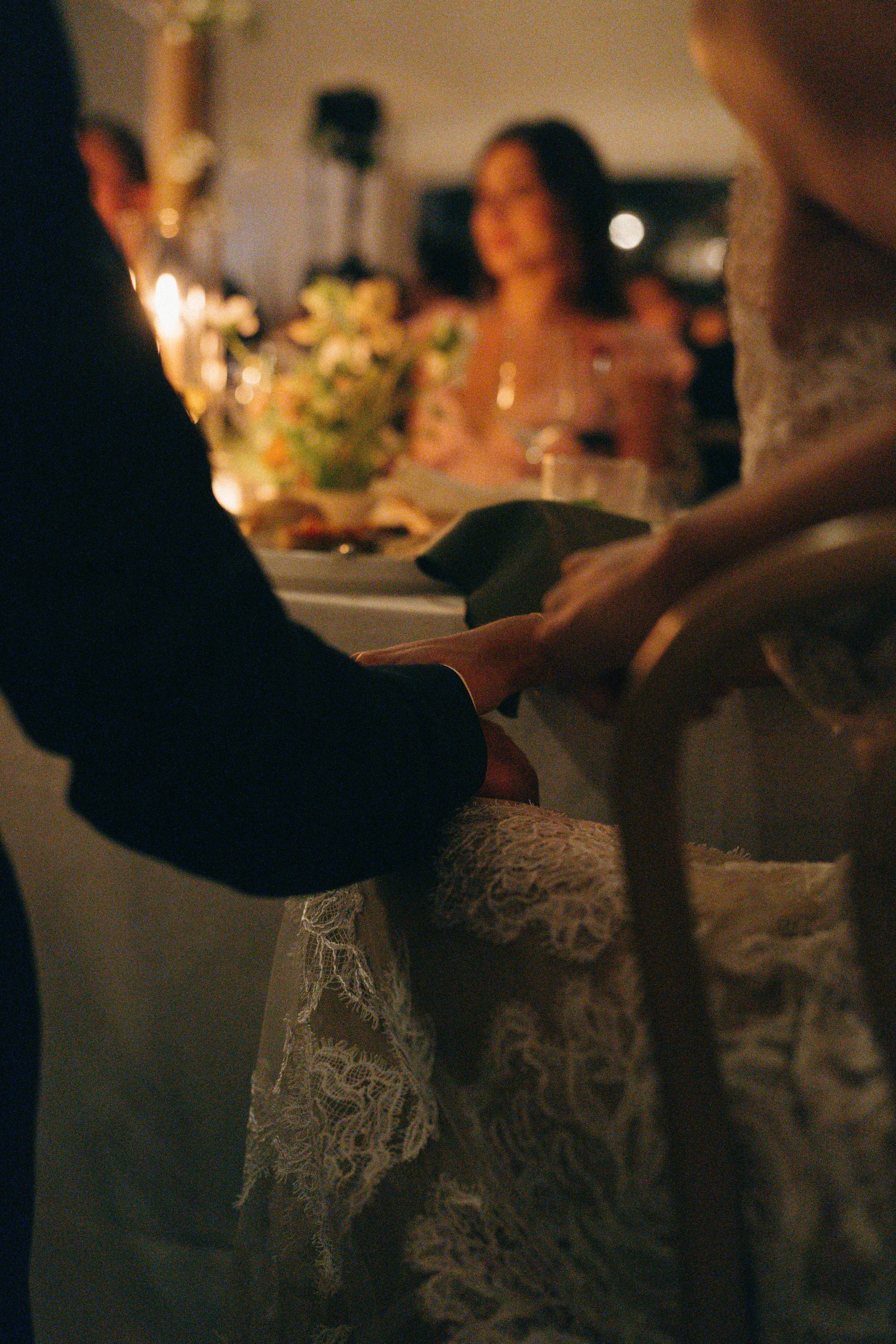 Intimate candlelit moment with floral centerpiece softly glowing on the table during the evening reception