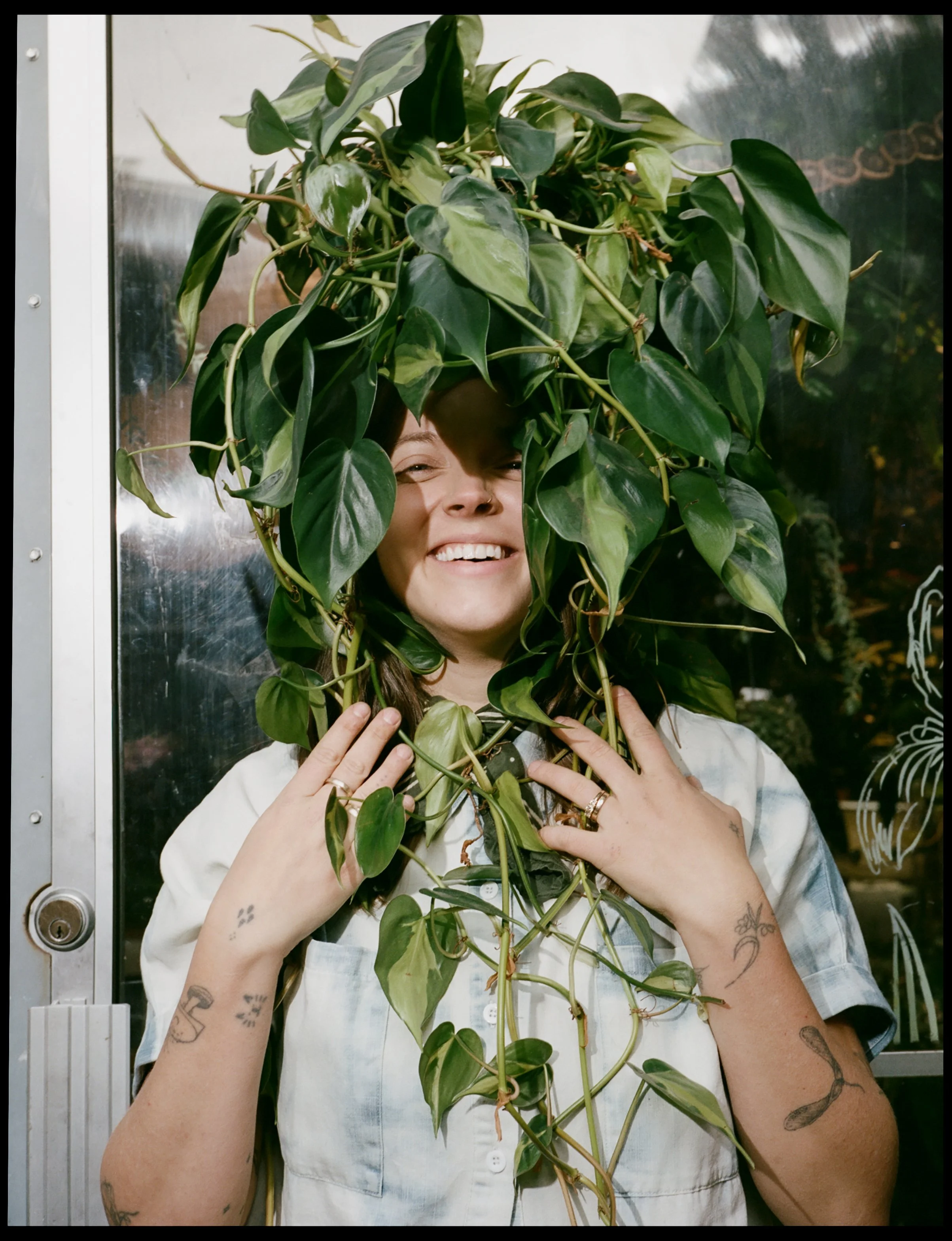 Corinne Bryson, founder of Flora Good Times, holding a lush houseplant inside the Beacon, NY flower shop.