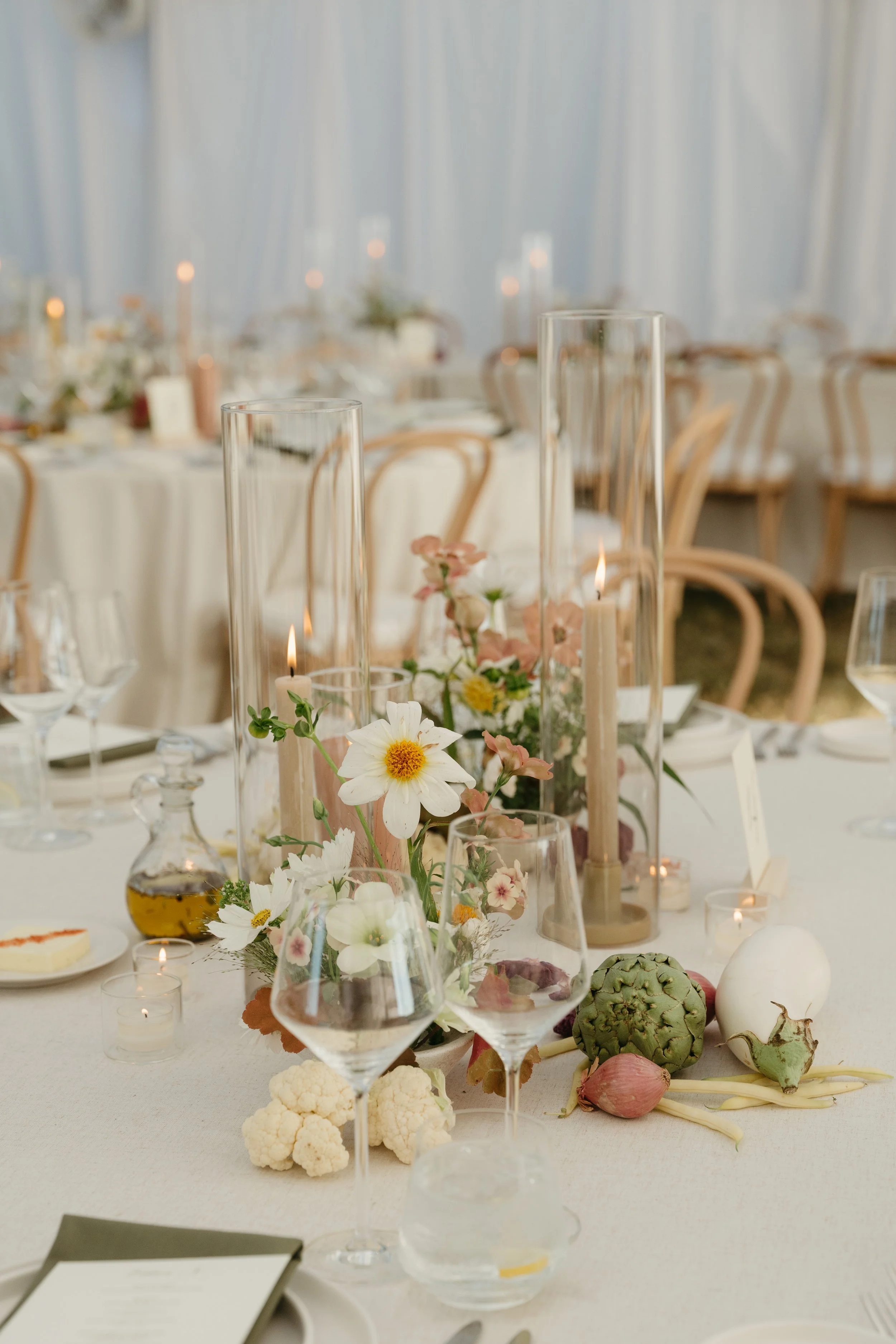 Low garden-style centerpieces with mixed seasonal flowers on round reception tables