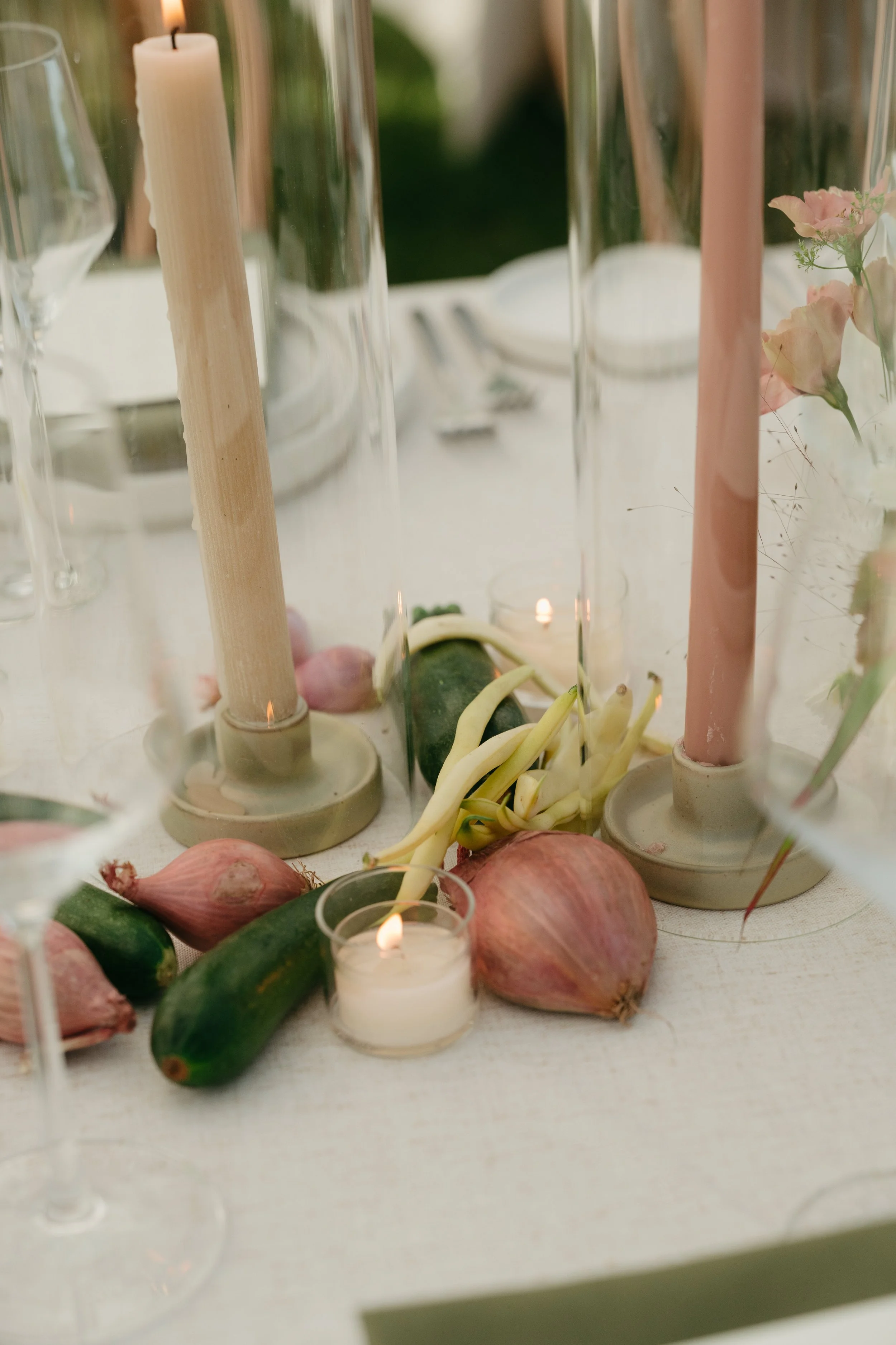 Seasonal table florals styled with taper candles and garden produce accents