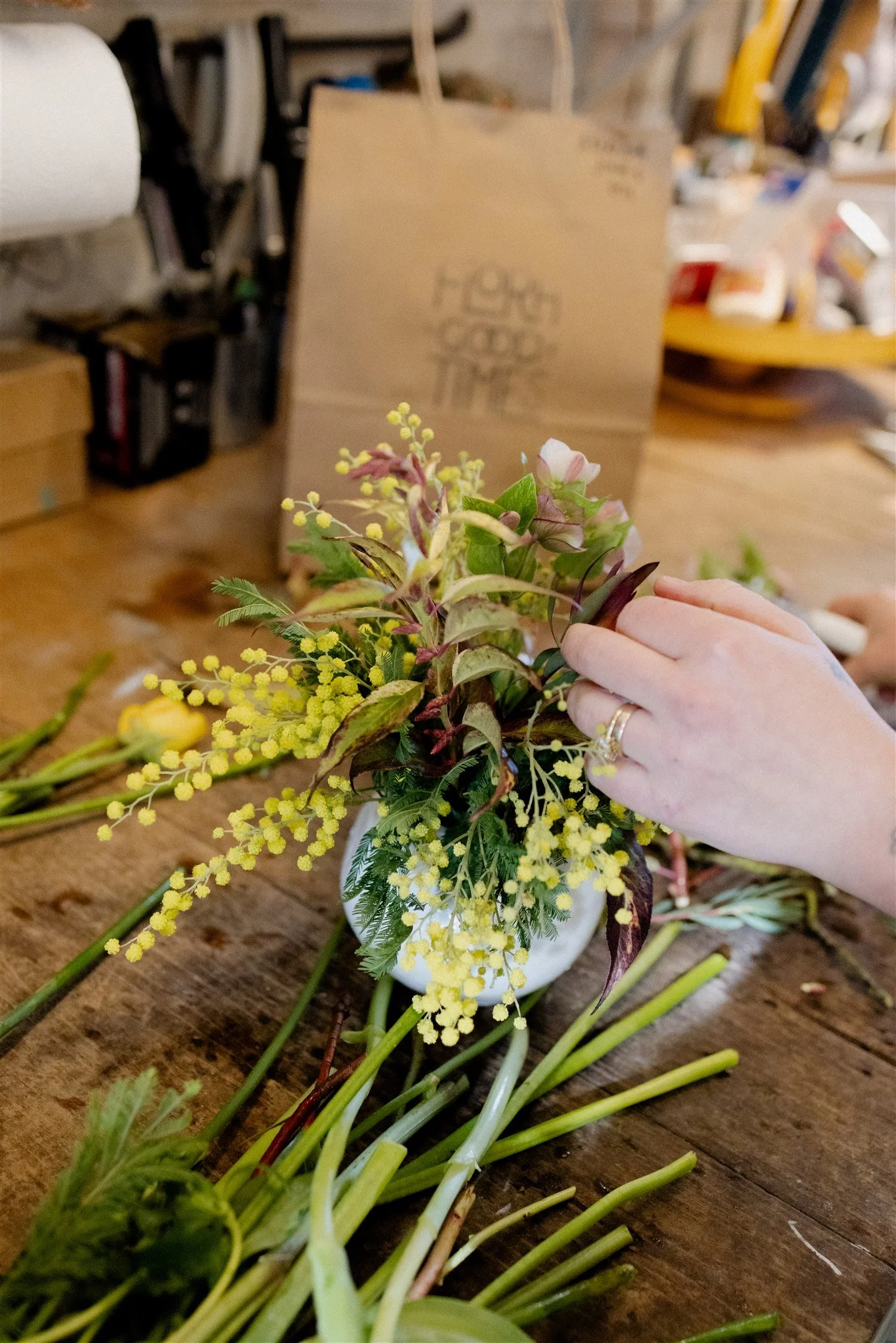 Hands arranging a seasonal arrangement in the Flora Good Times flower studio in Beacon, NY.