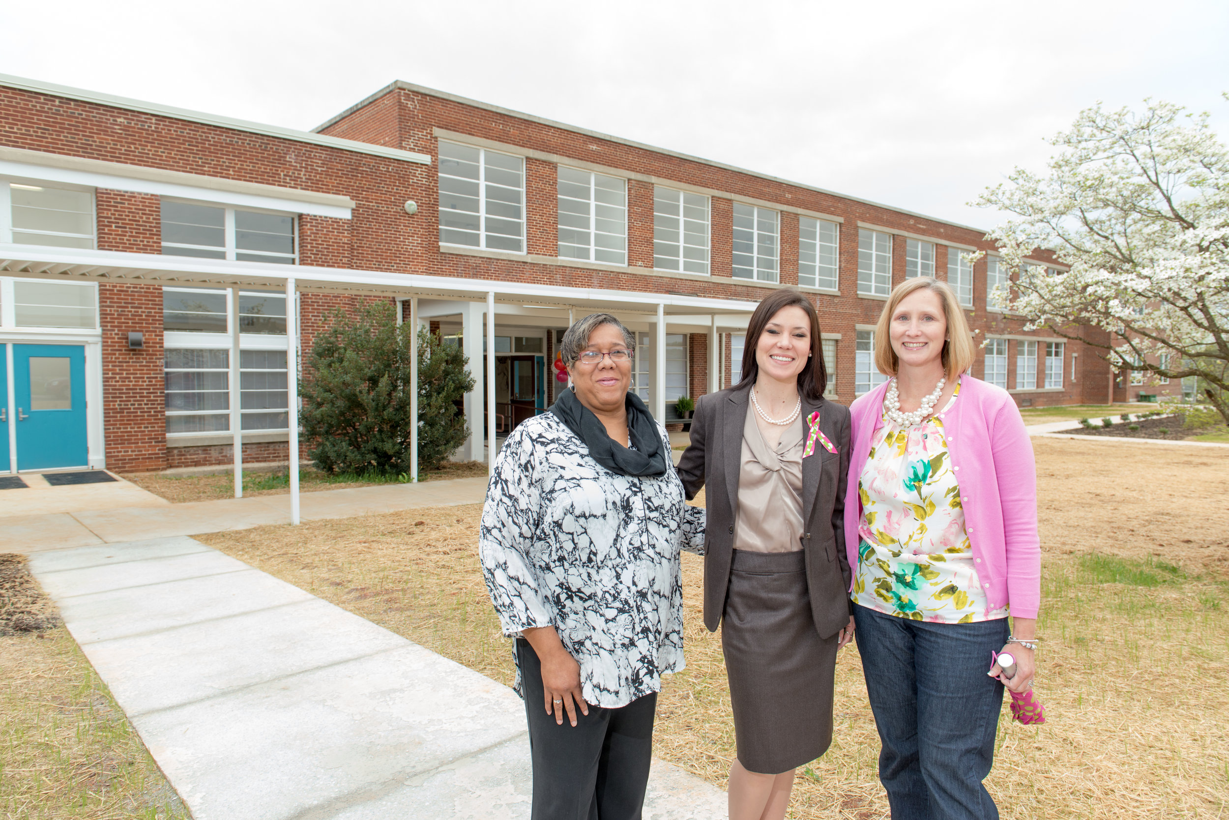 Rush Homes staff pose in front of the newly renovated Armstrong Place.