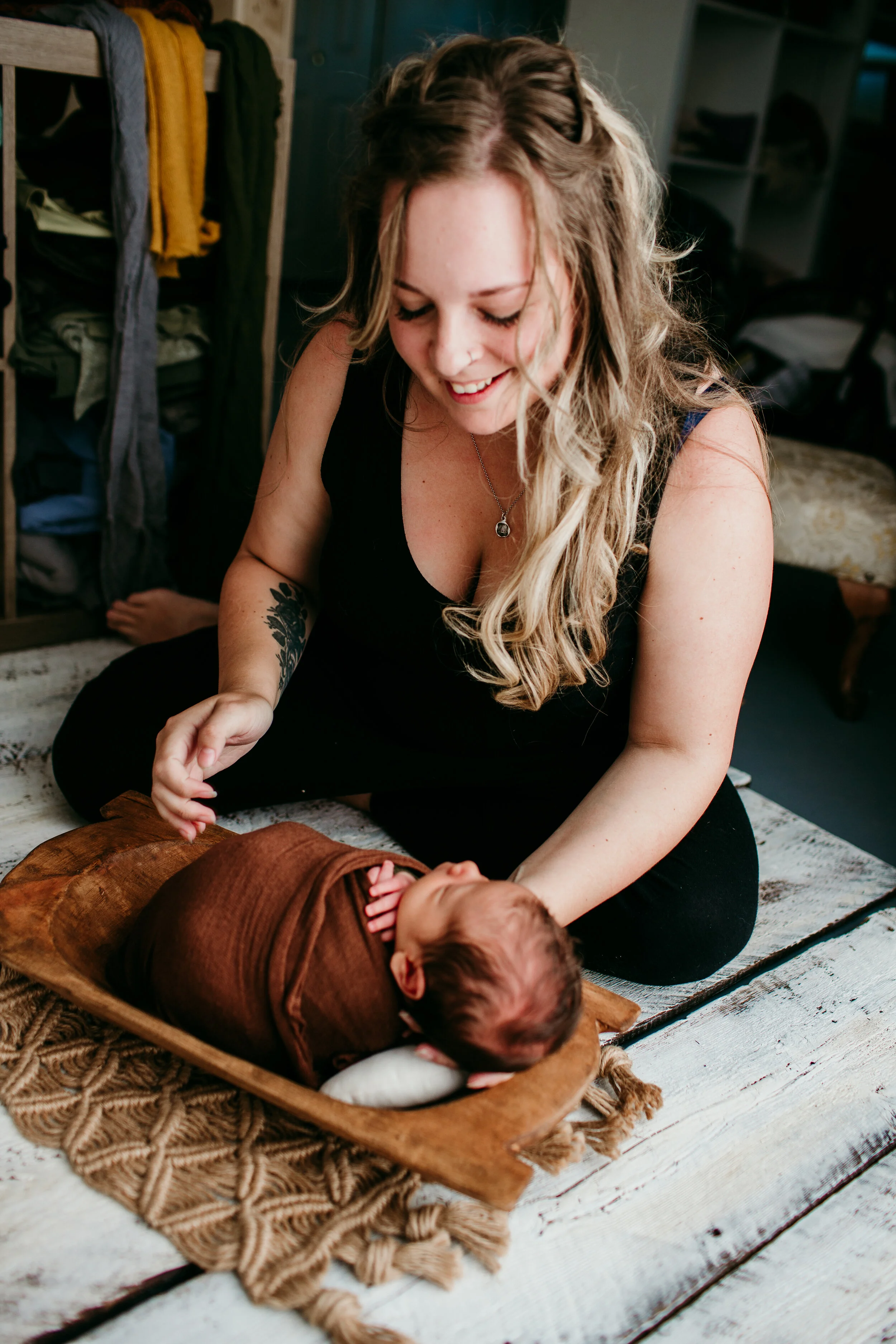 Ashlee placing a newborn in a prop