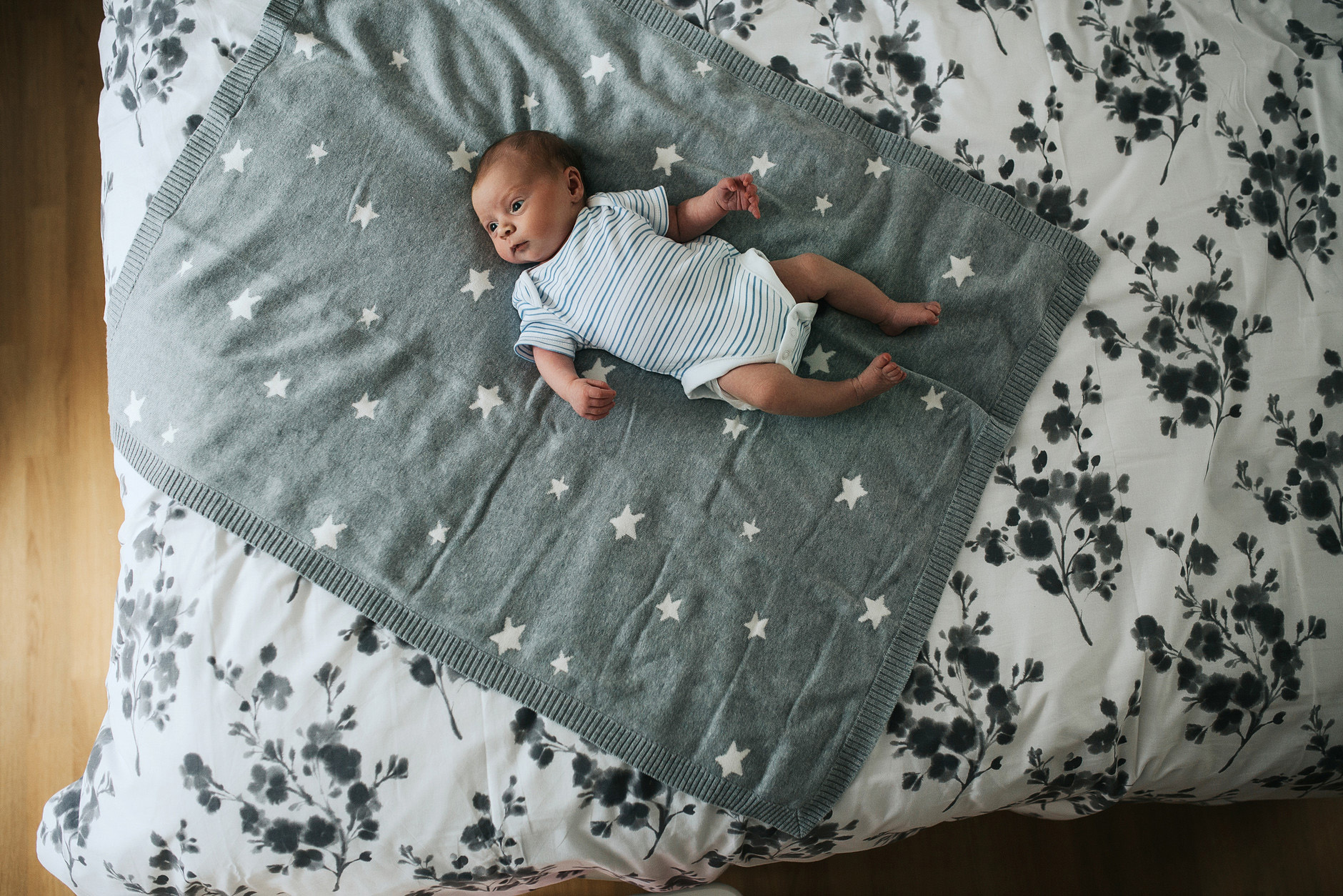 10-days-old newborn baby boy lying on his parents bed at home