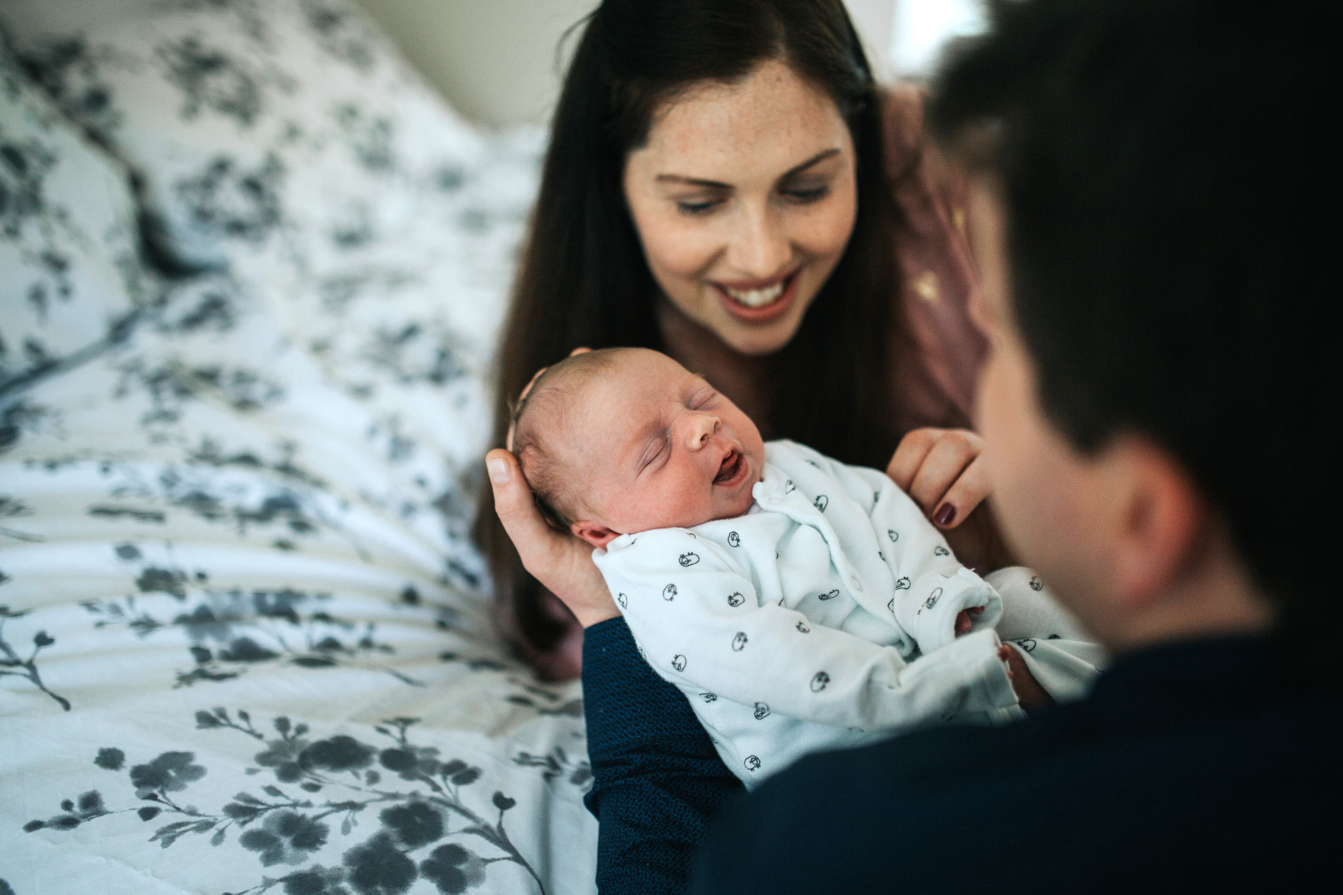 New parents admire their newborn baby at home