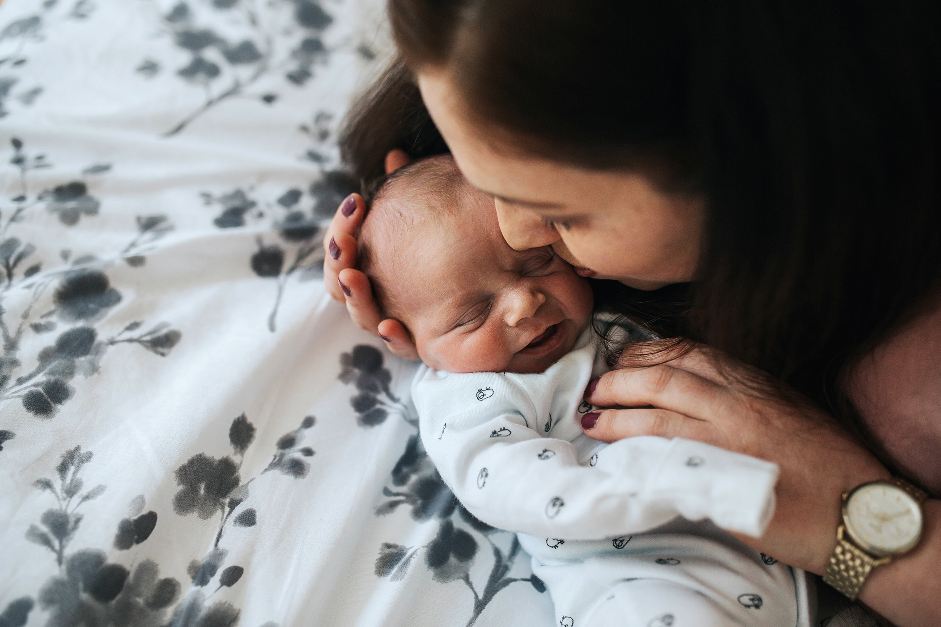 New mother kisses hew newborn baby on the cheek