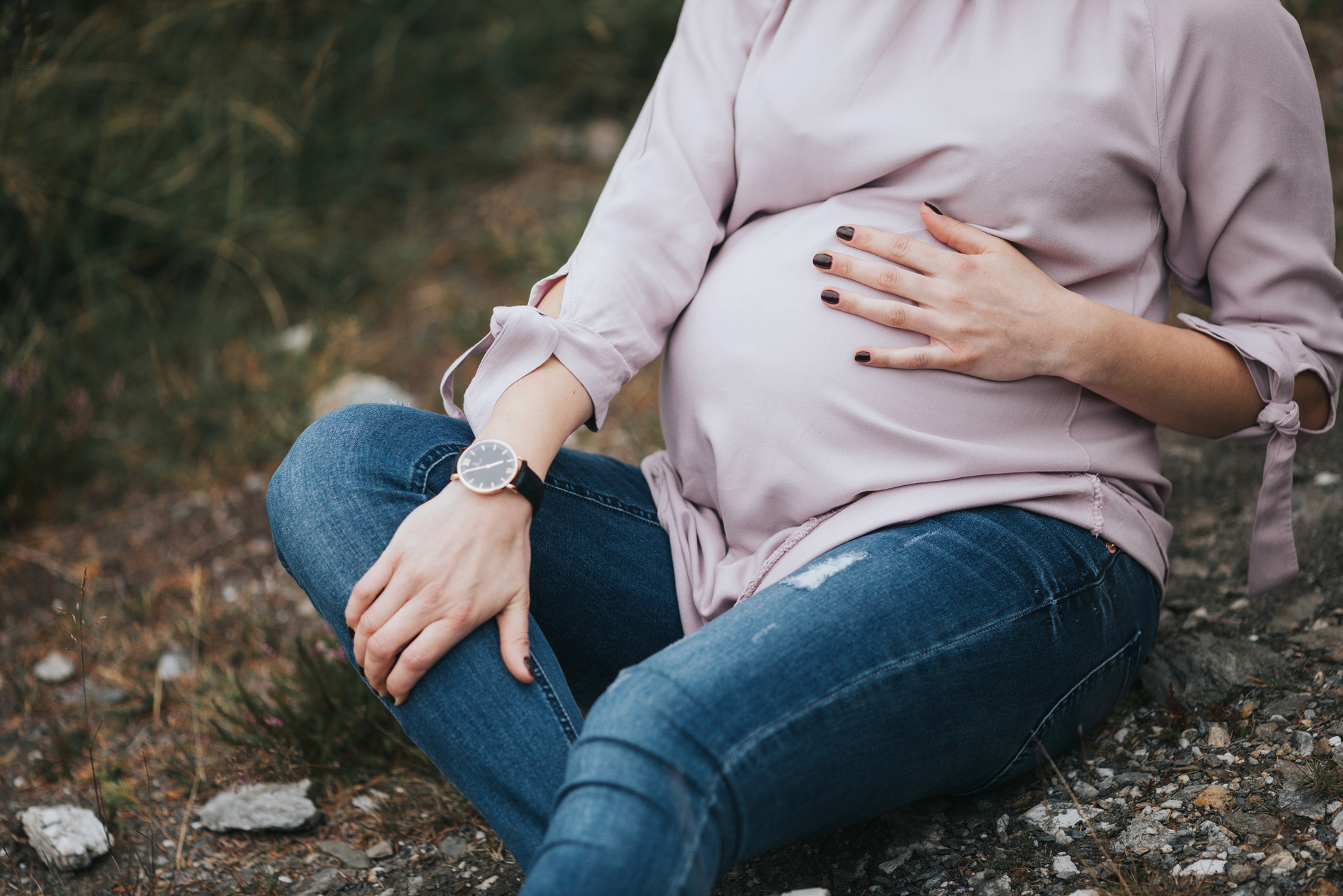 Pregnant woman lightly touching her pregnant belly