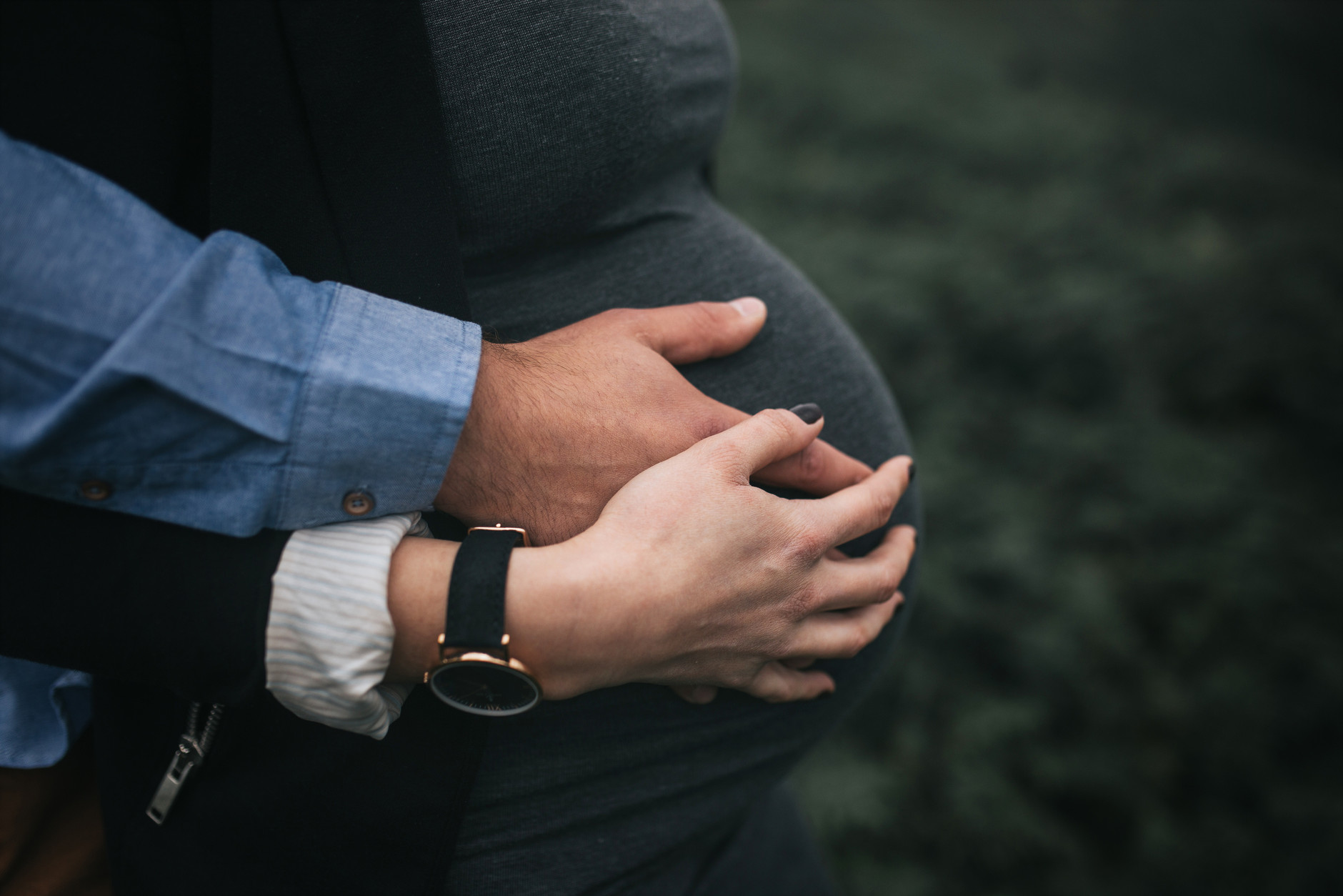 Pregnancy Photoshoot: two hands resting on a pregnant baby bump