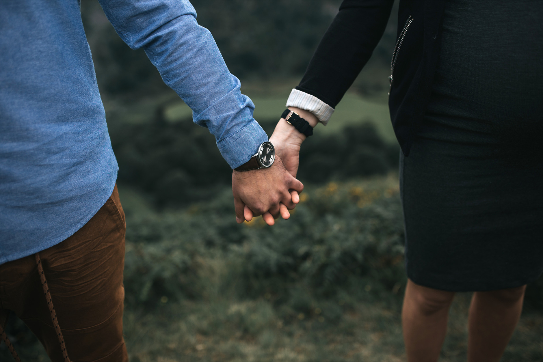 Couple holding hands during their maternity photoshoot