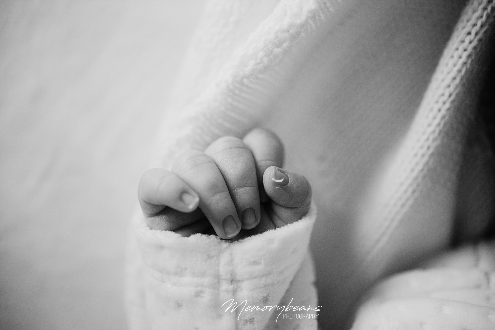 Close-up of newborn baby’s hand with broken tiny nail