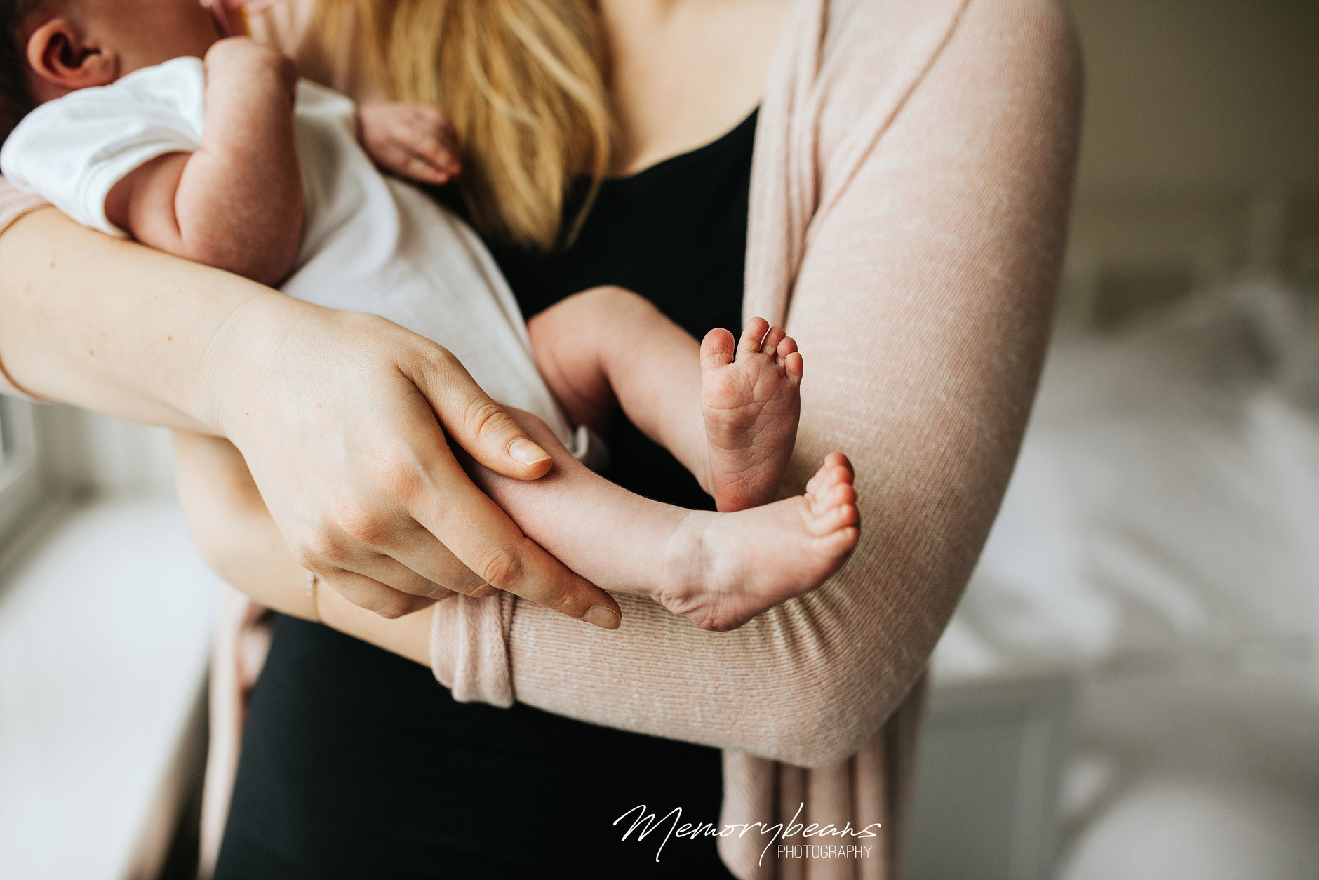 Photo of newborn baby feet in his mother’s arms