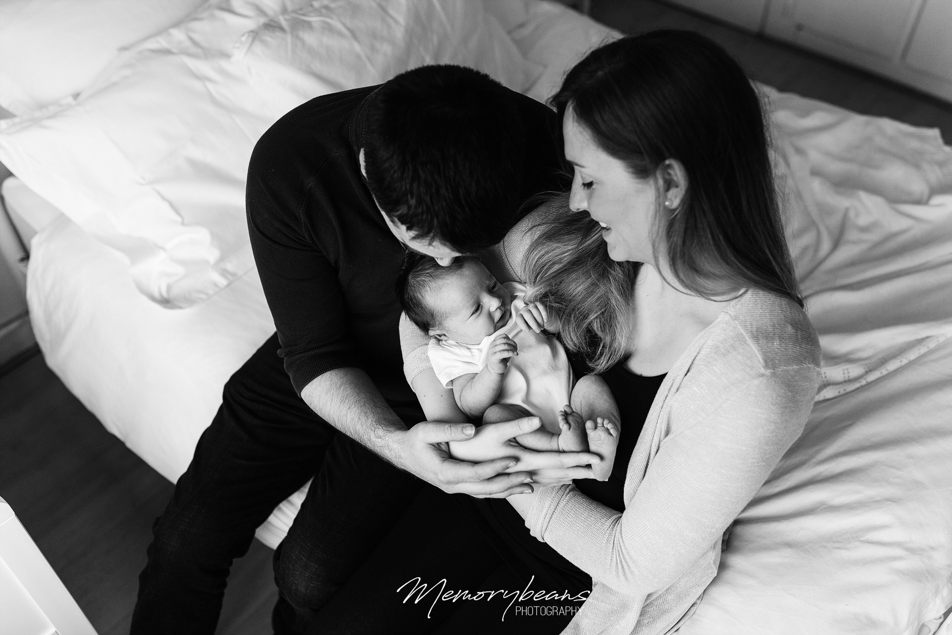 Black &amp; White Photograph of new parents holding smiling baby at home