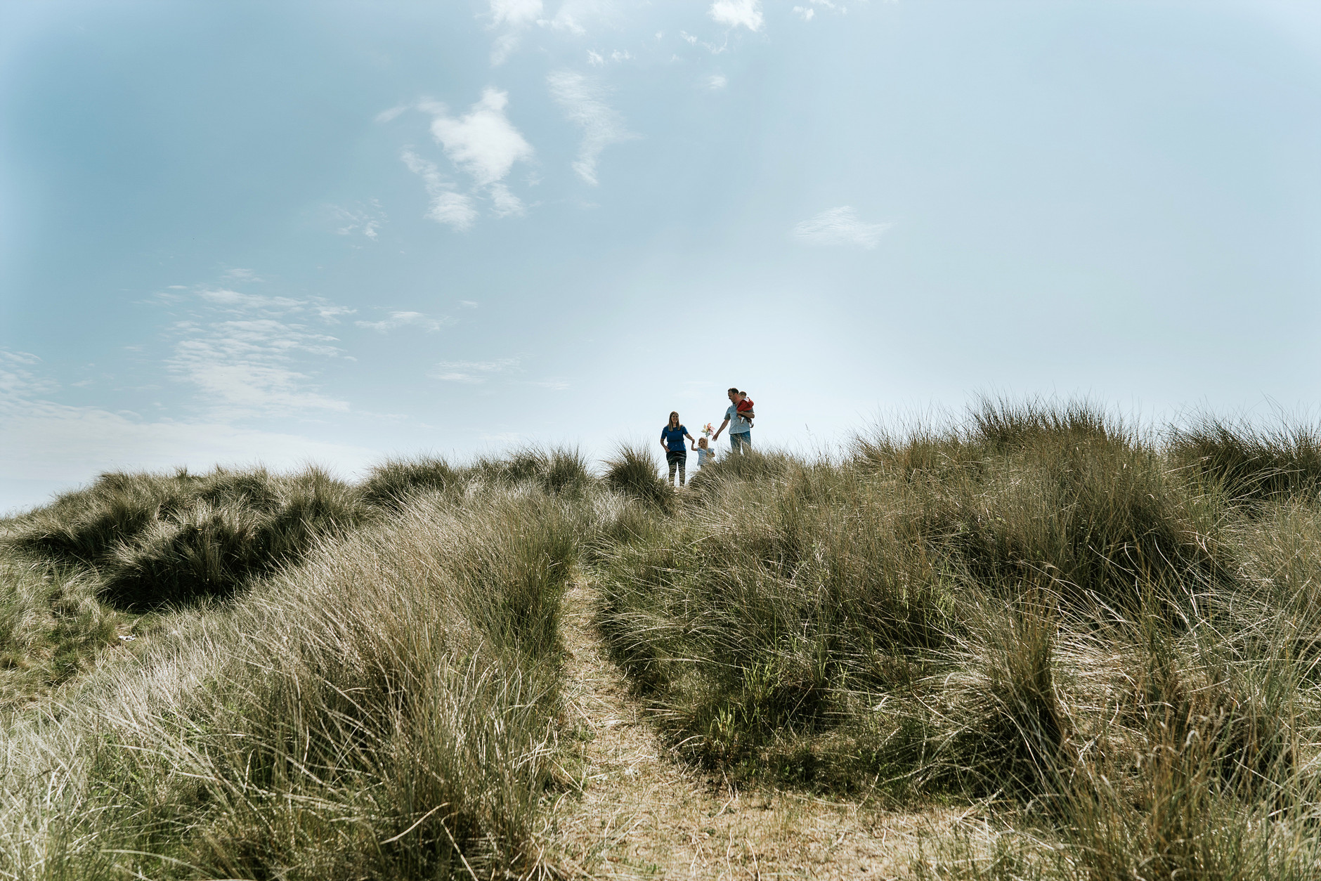 Family of four walking in the sand dunes in Bull Island, Dublin