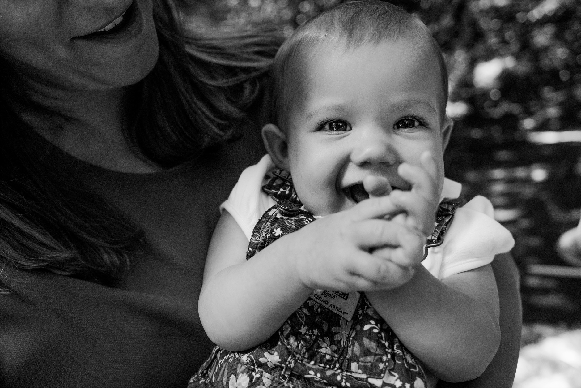 Baby girl laughing in her mother’s arms