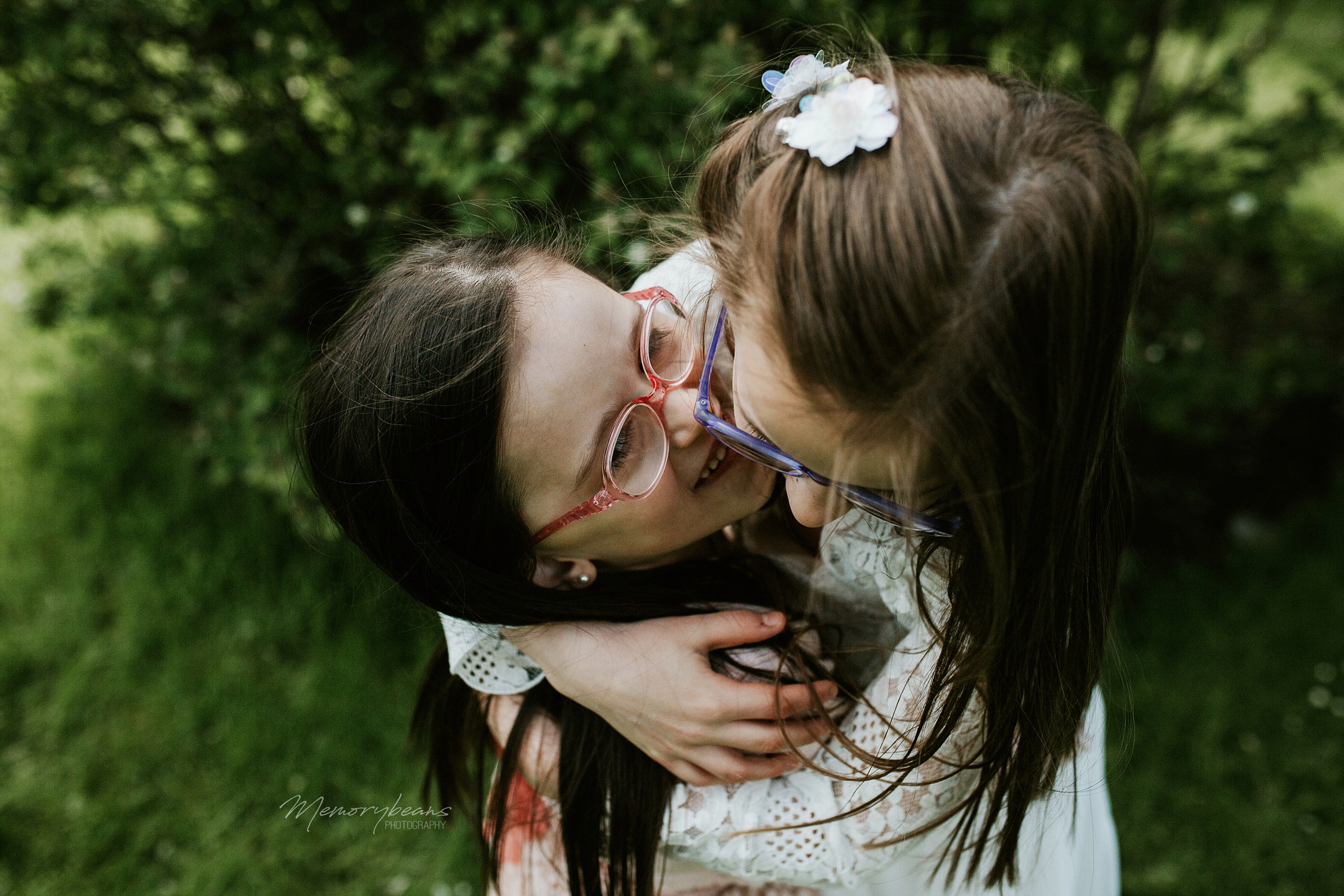 First communion photos, two sisters hugging and laughing