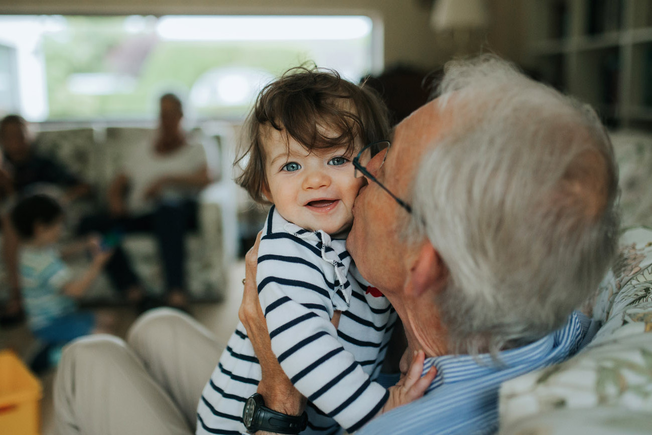 Grandfather kissing his smiling grandson on the cheek