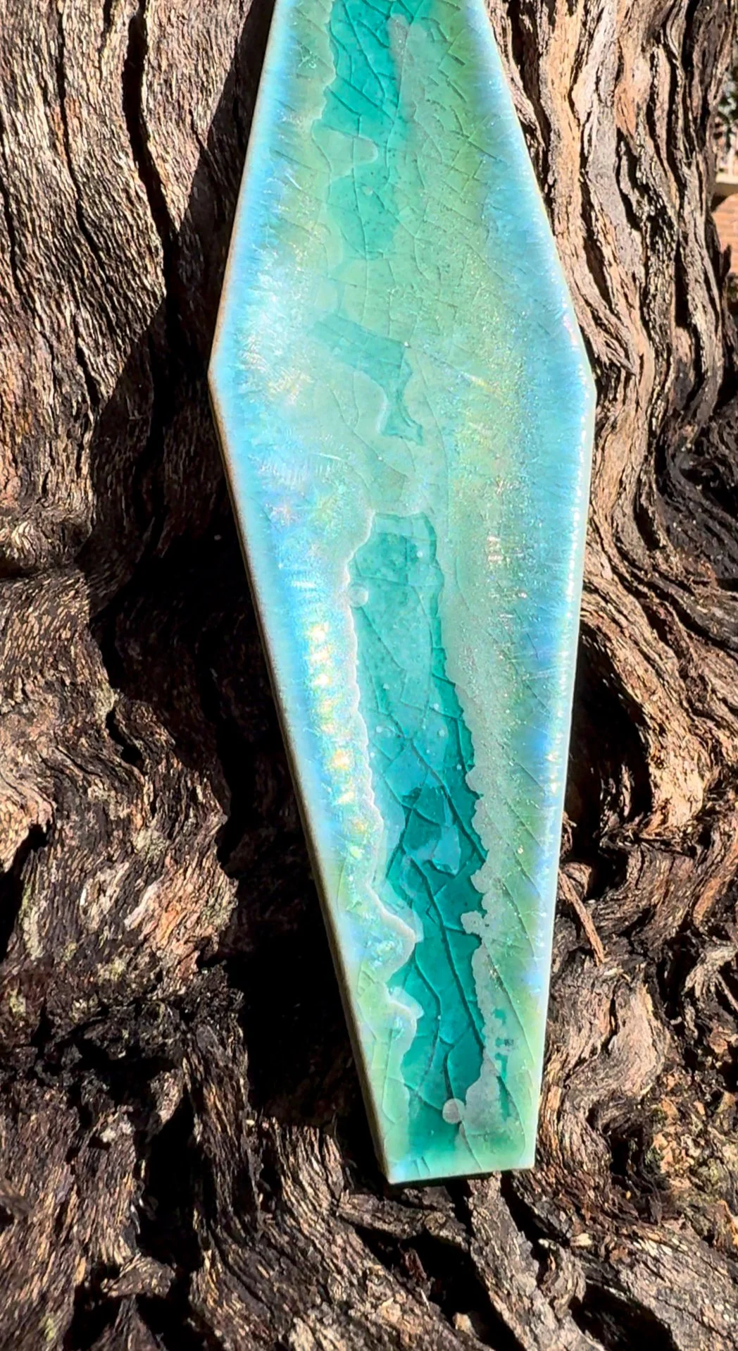 Handmade ceramic vessel by Japanese artist Rie Ochiai, featuring layered blue glaze that changes with light, presented within plonc. Library.