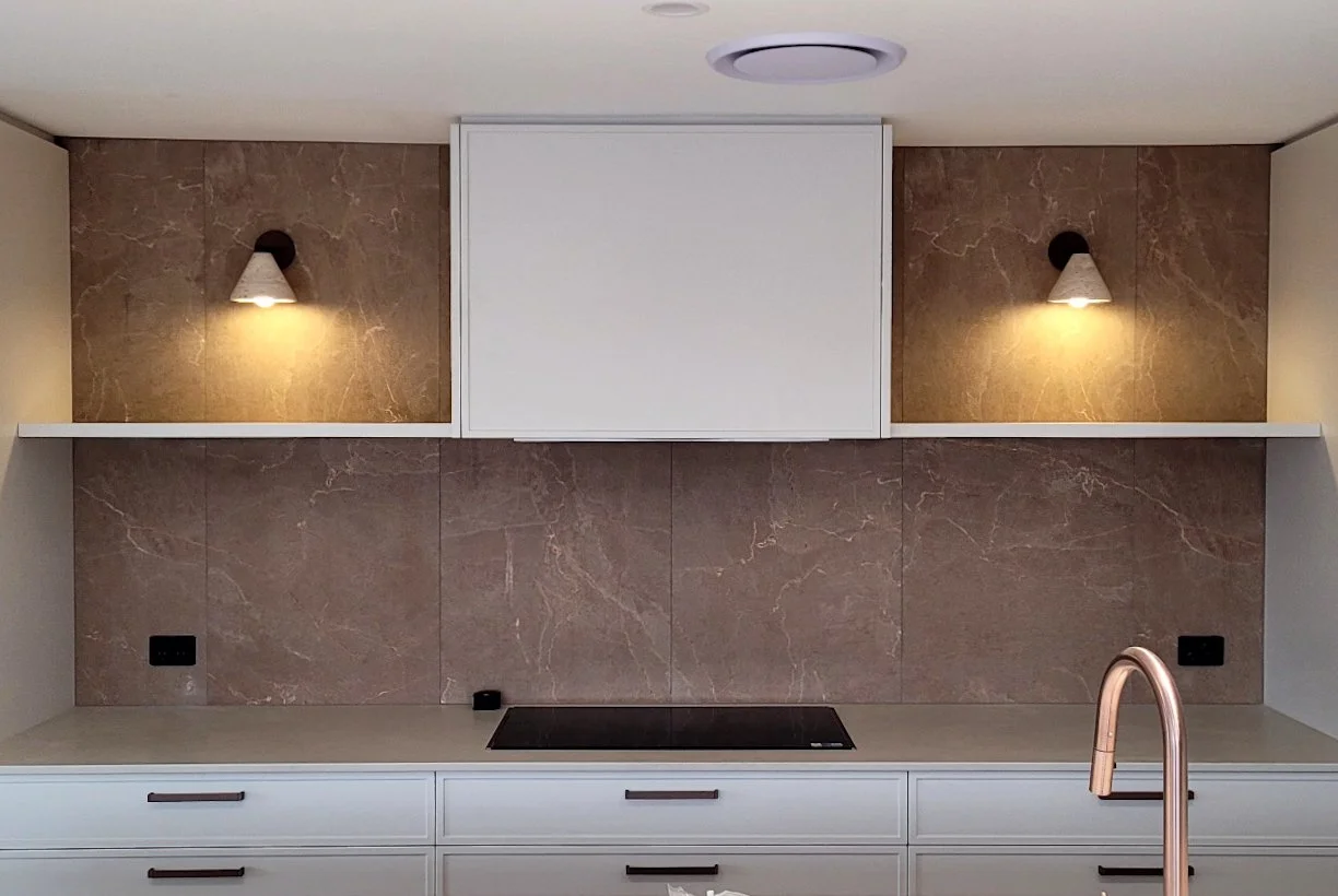 Dune Earth by plonc. installed as a large-format porcelain surface, showing sculpted weathered stone relief with warm earth tones and oxidised mineral texture inspired by eroded boulder formations.