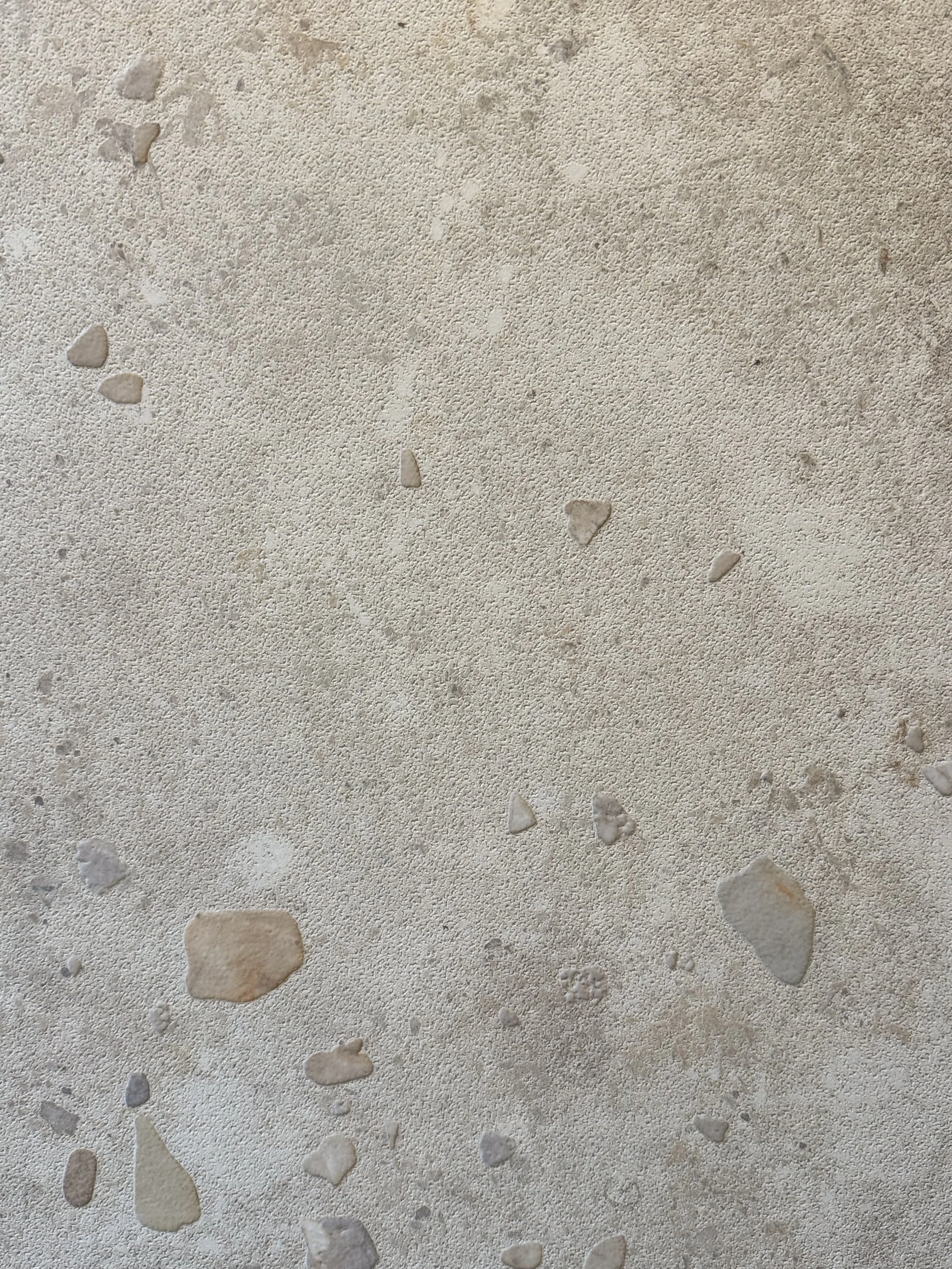 Ozpandi Textured porcelain surface featuring pebble-like sediment relief inspired by water-worn stone.