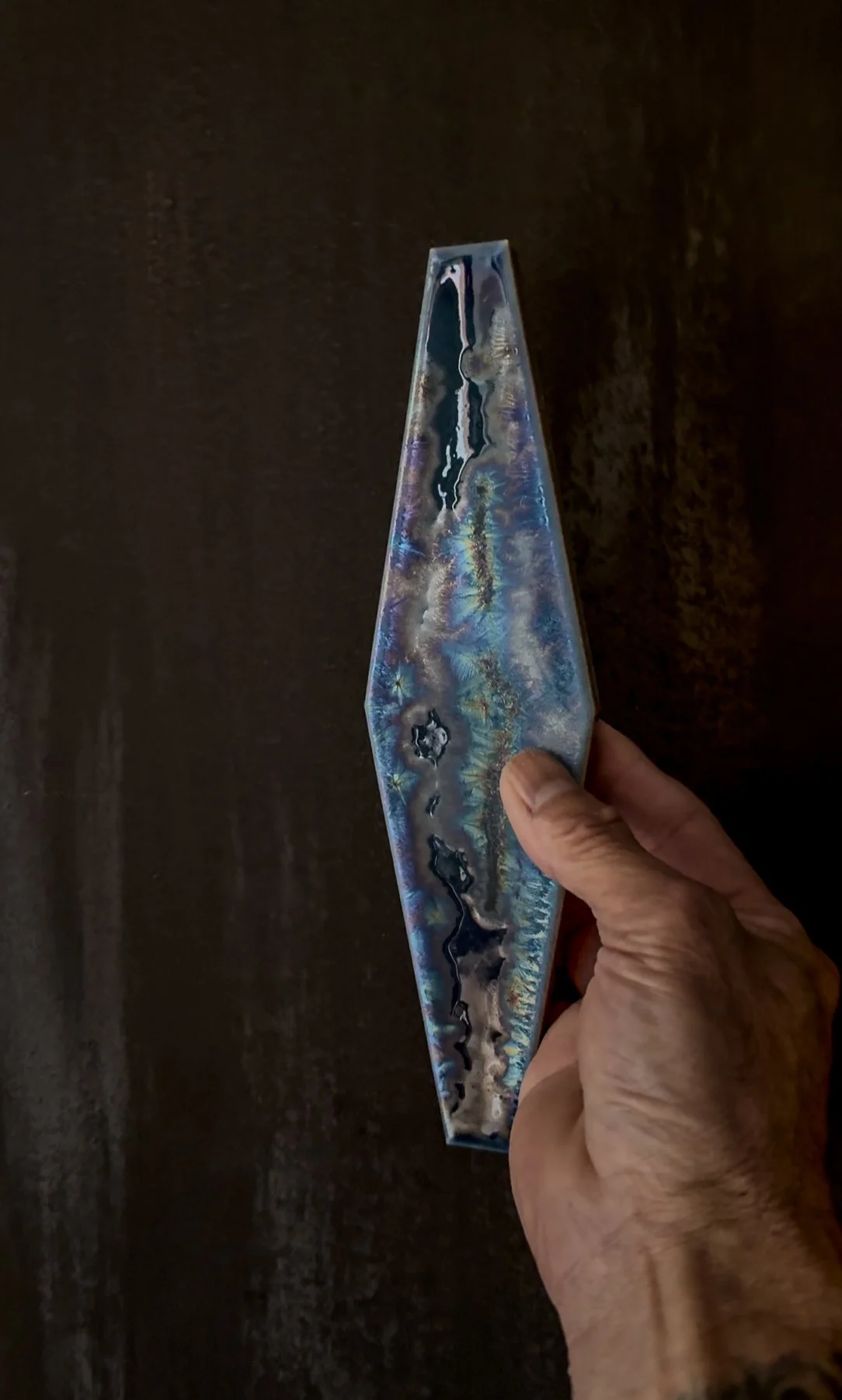 Close-up of Rie Ochiai’s handcrafted ceramic showing layered glaze, reflection and fired texture.