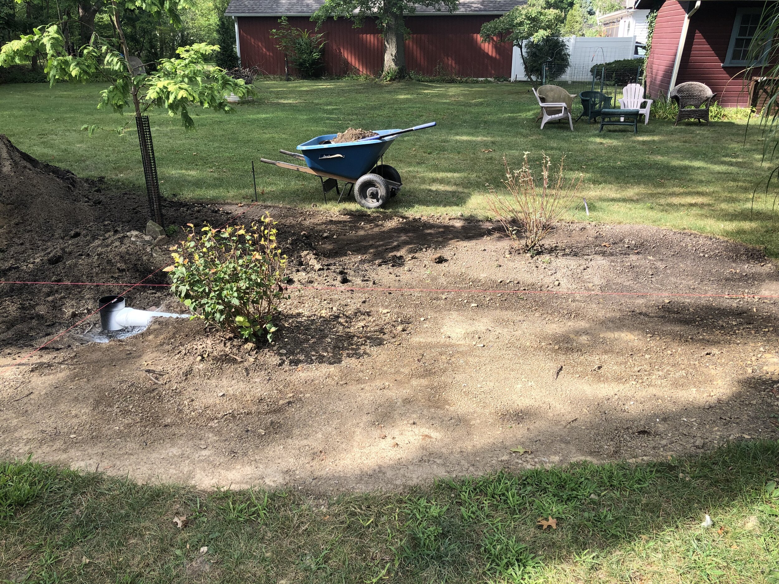  The existing drain was previously at the low point of the property line.  We modified it to be at the highpoint of the rain garden and to serve only as an overflow.  