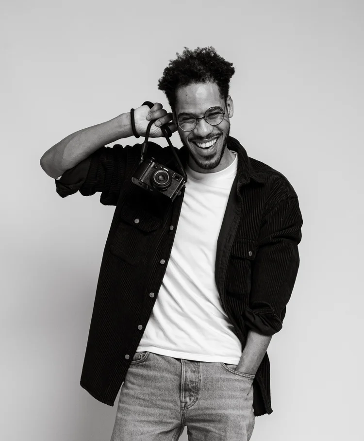 Merv laughing, holding a camera