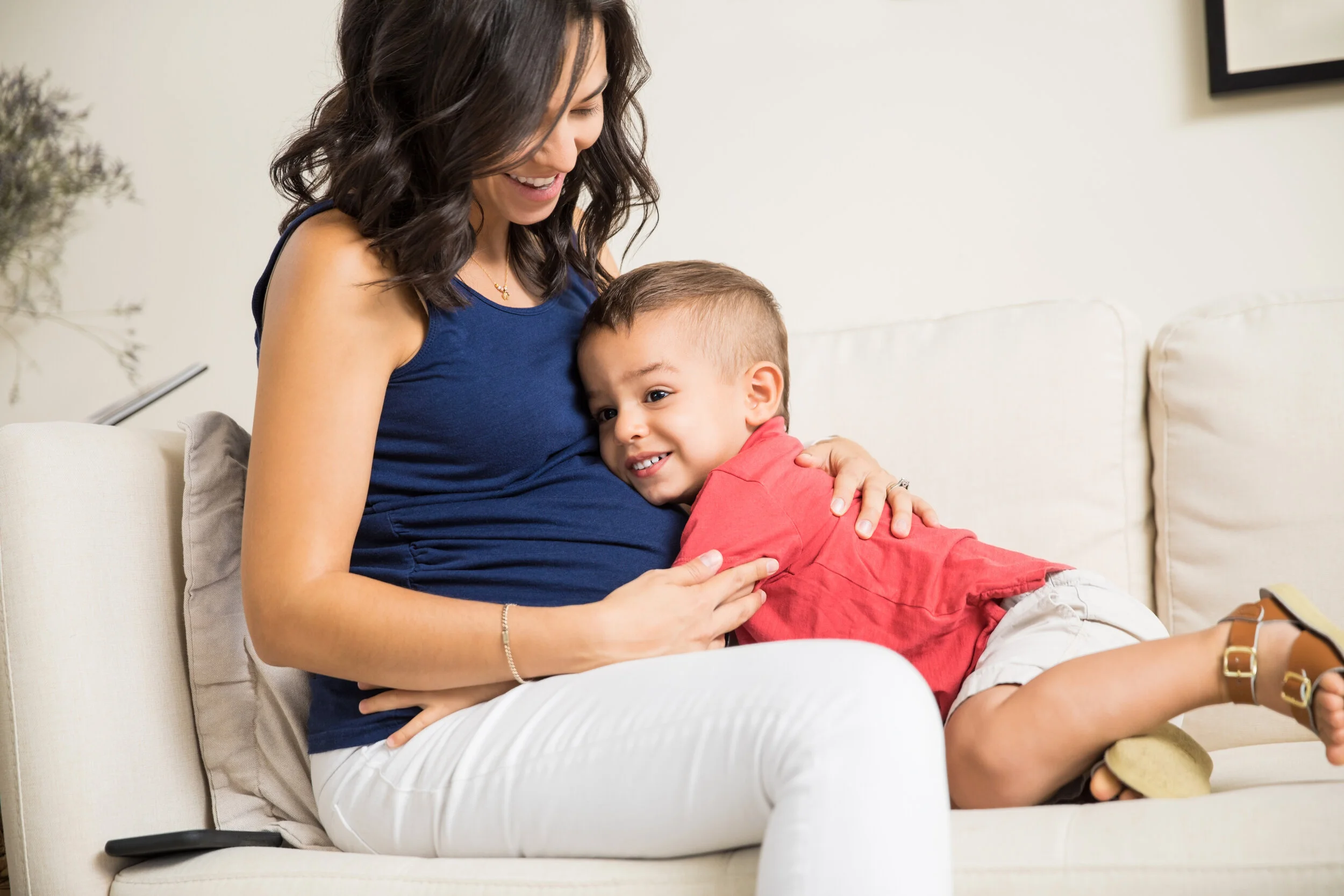 Happy mother and son seated on a couch, enjoying each other's company.