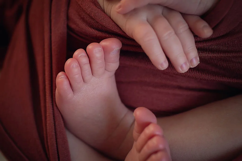 Close-up of newborn baby girl showing her feet and hands during a newborn session in Indianapolis.